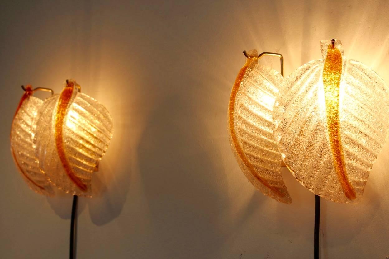 Wonderful set of wall lights made by A.V. Mazzega with beautiful characteristic Murano frosted glass leaves on a brass base. Manufactured in the early 1970s. Very impressive glass and beautiful light effect when lit. In excellent condition


 