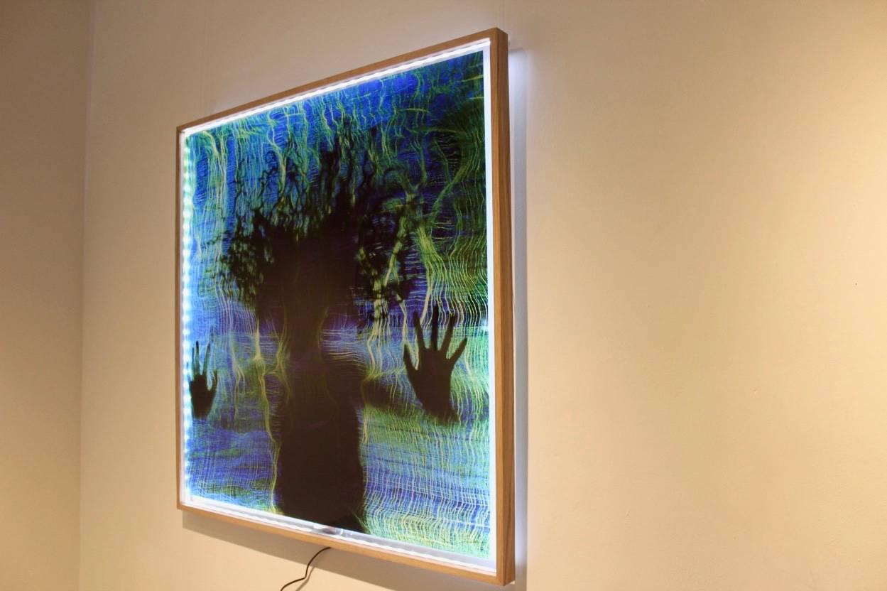 Une œuvre d'art spectaculaire de Lawrence Kwakye. Photo d'une œuvre d'art originale de Kwakye, imprimée sur Perspex, encadrée en chêne et éclairée par des lumières à DEL. Cette photo capture un moment d'interaction avec l'une des œuvres d'art