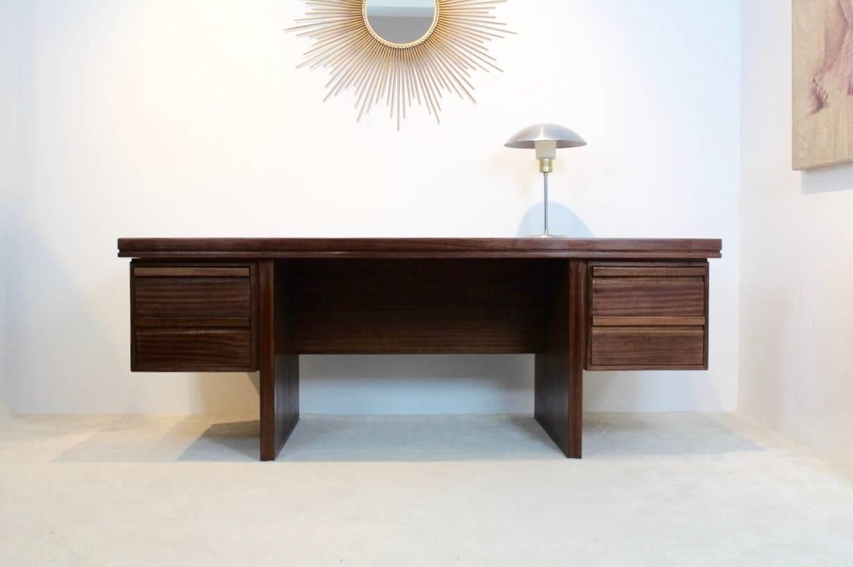 Beautiful Dutch teak executive desk coming from the executive room belonging to the old Philips Electronics Company in the Netherlands. This desk is really heavy duty and in a very good condition. It comes with four drawers and the finishing is