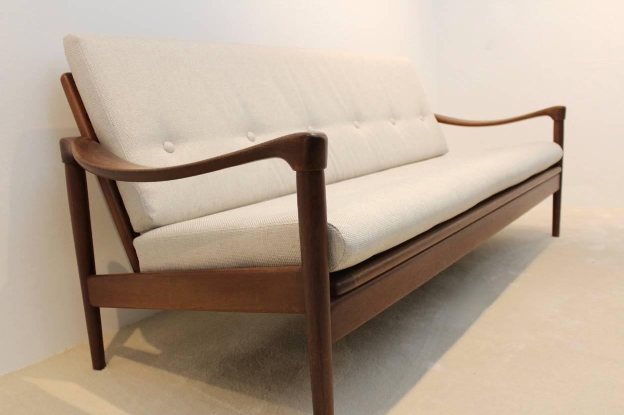 Mid-Century teak sofa produced and designed by de Ster Gelderland, Holland, 1950s-1960s. Three-seat sofa in original state with new upholstery with cream toned tweet. Very beautiful organic shape teak wooden base. Original elastic straps in good