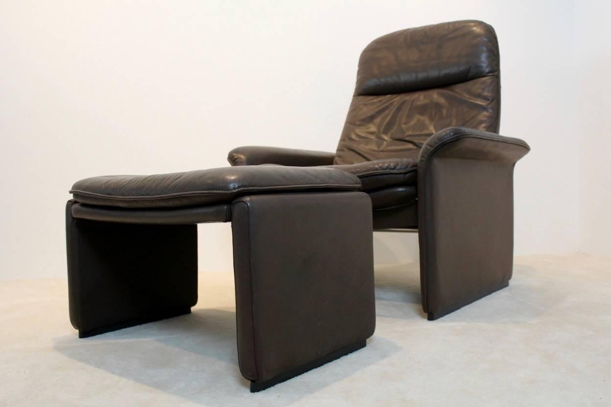 Exceptional De Sede DS-50 adjustable lounge chair with ottoman in thick buffalo leather. The fine chocolate brown leather is in superb condition with amazingly beautiful patina. Manufactured in the 1970s on a heavy frame of solid wood with the