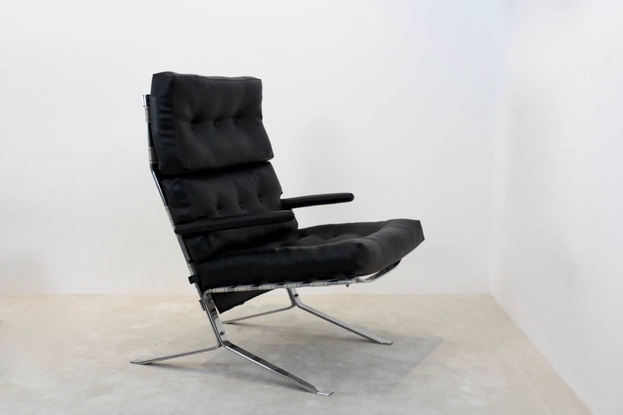 Rare version à dossier haut d'une chaise longue belge, avec une structure en acier fortement chromé et un revêtement en similicuir noir. La chaise est numérotée, nous ne connaissons pas le fabricant. Design/One, vers 1975.

Consultez notre vitrine