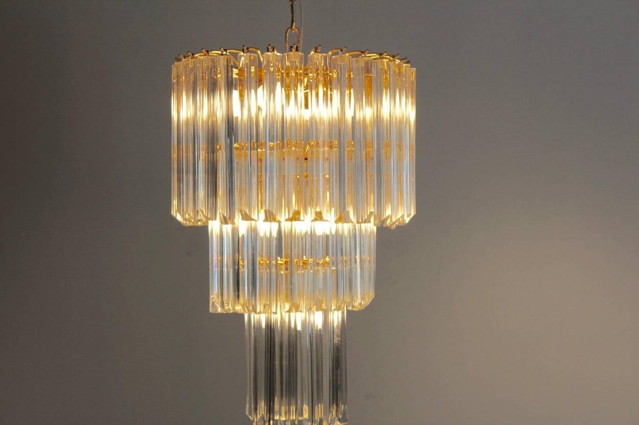 Sophisticated chandelier designed by Paolo Venini and produced by Venini with 60 pieces trilobe Murano glasses on a gilded three tiers structure. Comes with 60 pieces of Murano glass and eight light bulbs. In very good condition and with beautiful