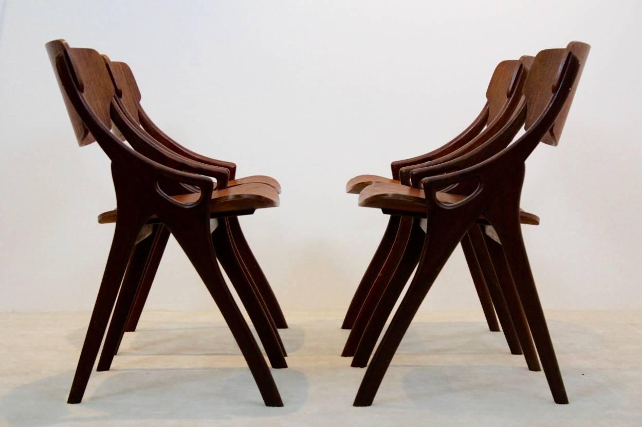 Set of four dining chairs designed by Arne Hovmand Olsen and manufactured in Denmark by Mogens Kold during the 1950s. Each chair features sculpted mahogany arms with teak backrests and seating/has been recently reupholstered. All the chairs are in a