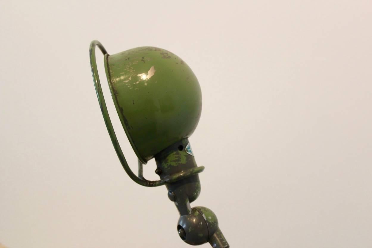 Originally pair Industrial lamp for Jieldé designed by Jean Louis Domecq in the 1950s in France. Very beautiful Industrial patina in old green. This two armed example is in full original condition and marked with the original plate. It features an