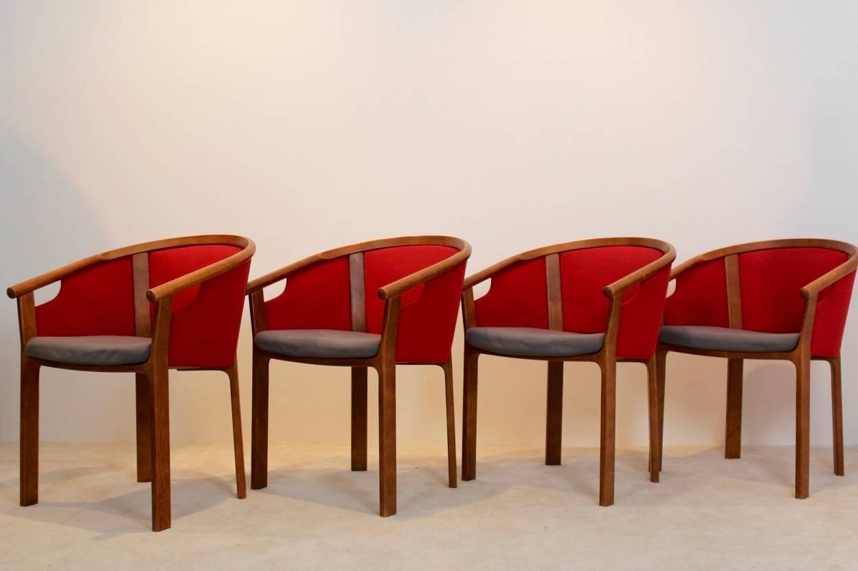 Set of four dining chairs designed by Rud Thygesen and Johnny Sørensen and manufactured in Denmark by Magnus Olesen during the 1980s. Each chair features sculpted teak frame arms with comfortable upholstery and a perfect sit. They were made without
