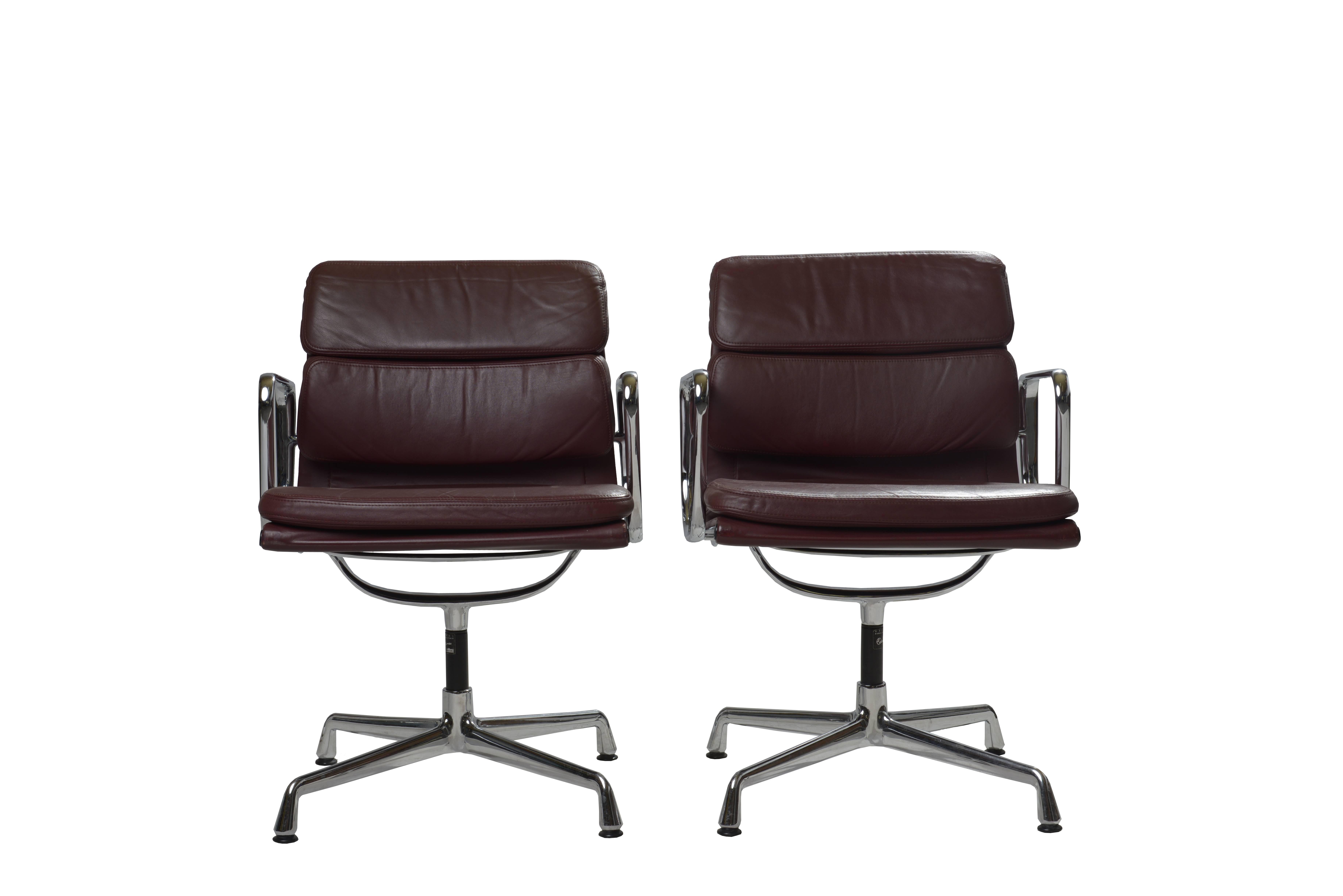 Pair of soft pad chairs model EA 208 designed by Charles and Ray Eames for Vitra, 1960s.

The seats are padded in their original soft burgundy leather, on a cast aluminum frame with plated chrome and a four-star base. Marked with label and stamped