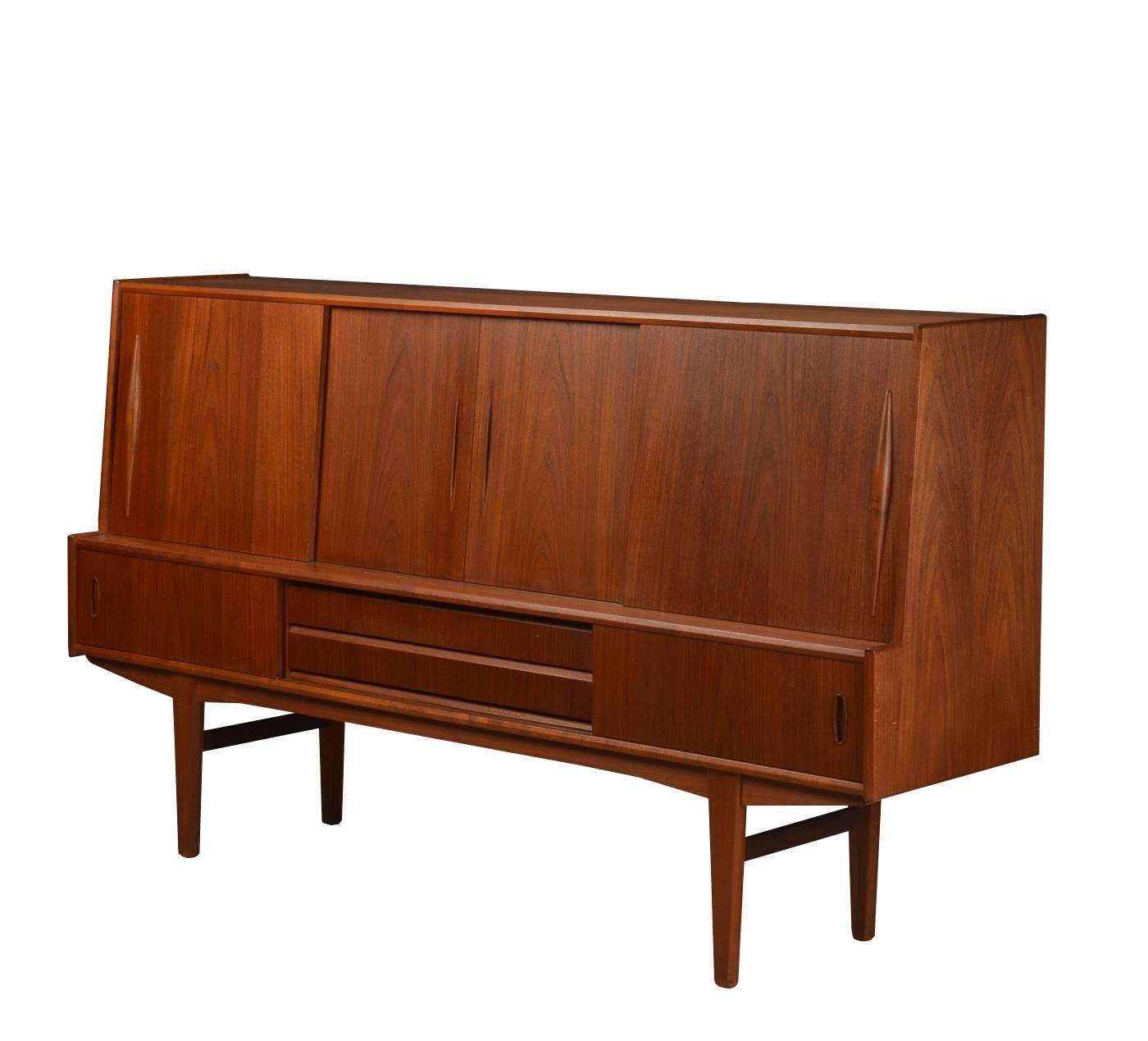 Mid-Century Modern sideboard in teak, Denmark, 1960s. Has front sliding doors, drawers and interior bar storage with mirror and shelves. Marks on top. Overall in good vintage condition.