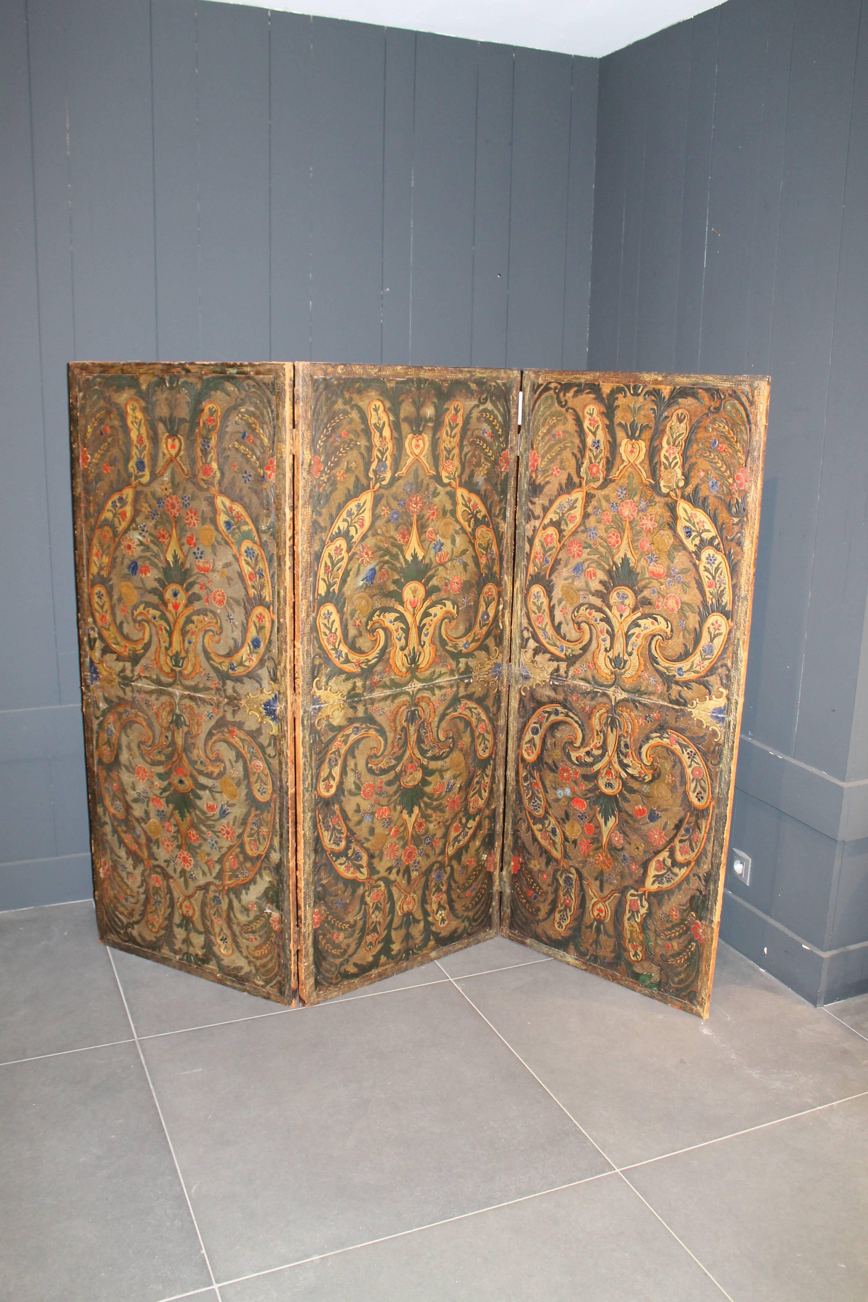 An antique Spanish embossed, painted and gold leaf leather screen with three panels 18th century. It is a double sided screen. This screen consists of a striking design combining both the tactile method of embossing a raised design upon the smooth