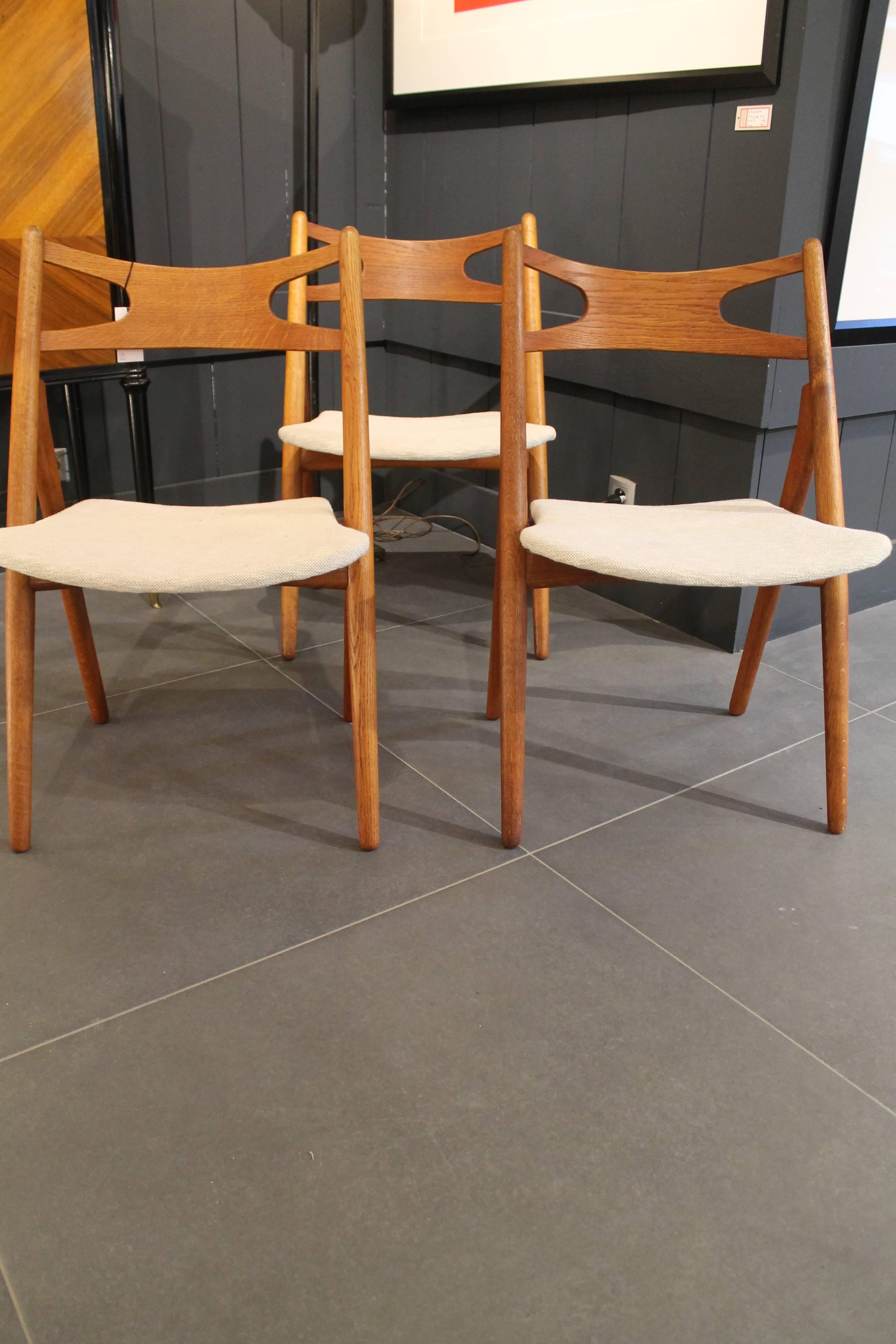 Six Hans J. Wegner dining chairs produced by Carl Hansen and Son in Odense, Denmark. It is a very old set with nice vintage fabric. The frame are cof solid oak and the backrest in veneered teak. Signed with branded manufacturer's mark to underside