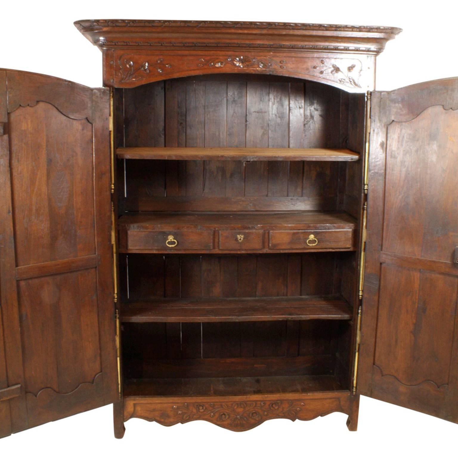Dating from the mid-late 1700s, featuring three large brass hinges on each door, long detailed escutcheons, three interior shelves and three drawers, one with a key. Beautiful patina inside and out. The inside left door clasp and locking mechanism