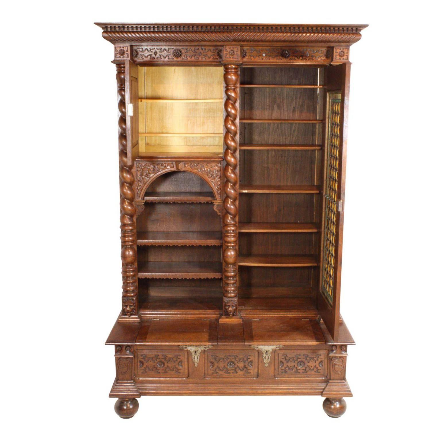 This bookcase is a stunner. Intricately carved embellishments from head to toe, including: Barley twist columns, lions heads, Green Men with vines, scalloped shells and shields, this piece needs to be seen up close and in person. The Leaded glass