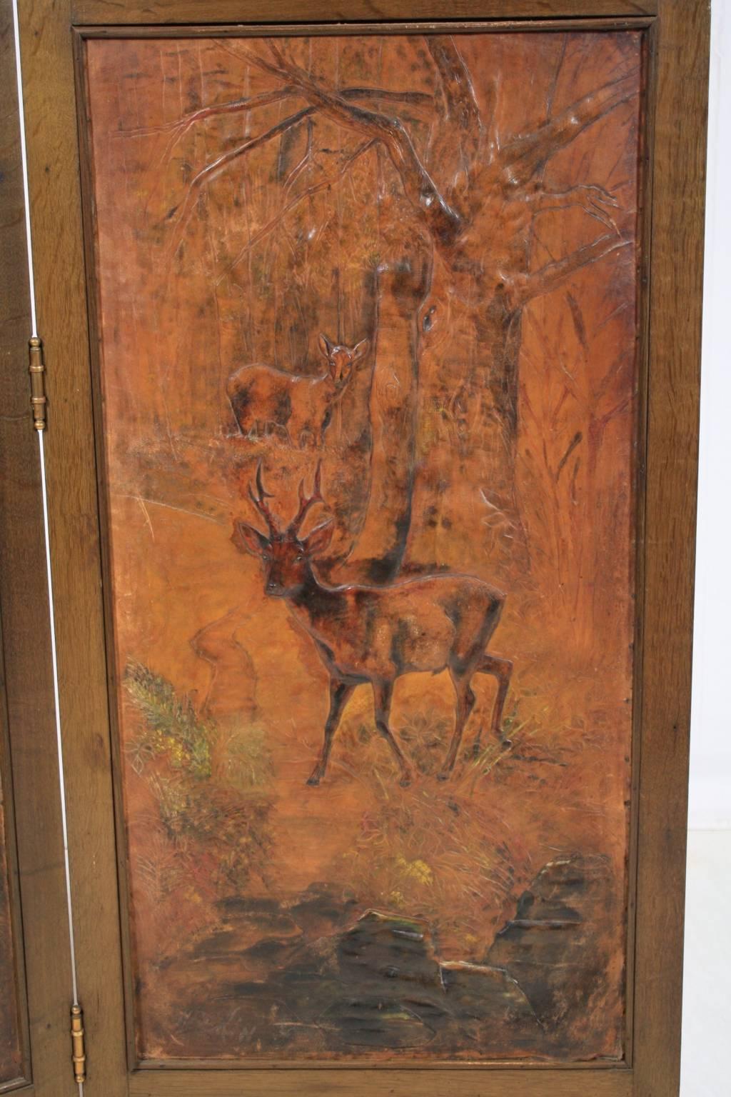 The lower front panels are woodland scenes featuring stag and deer in pressed leather with hand coloring. The upper panels are pressed copper and feature scenes with hunting dogs and their game. The backside of each screen is equally as beautiful