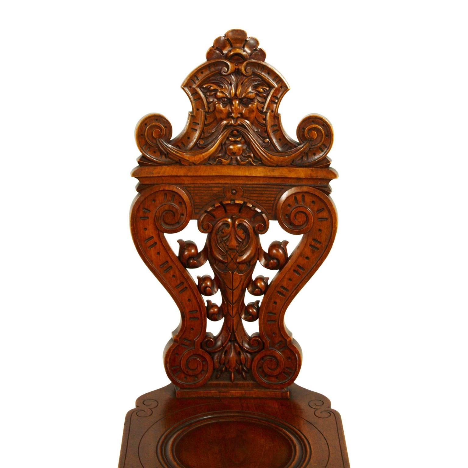 The thin width of these exquisitely carved Brienz side chairs, features foliate heads or 