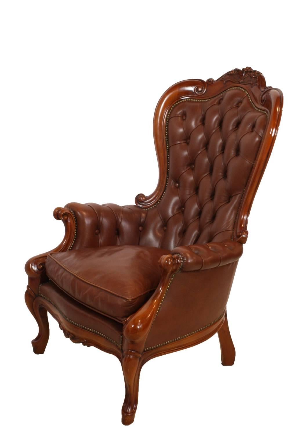 A pair of beautiful mahogany chairs with brown tufted leather and brass pinning in a classic Victorian style.