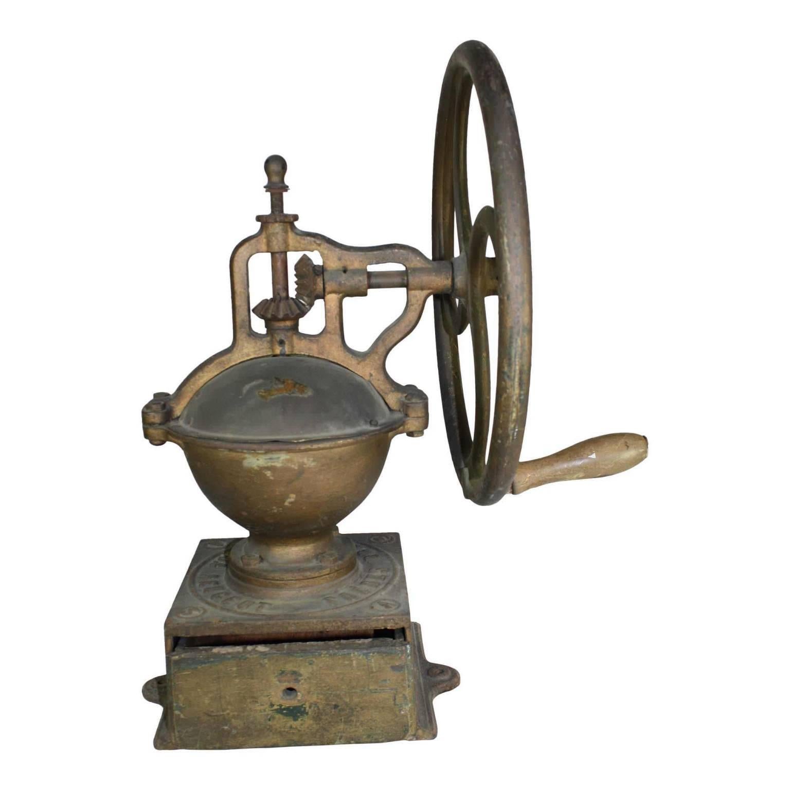 An early Industrial coffee grinder from the famed French manufacturer, Peugeot Freres. One of the larger of their cast iron wheels measures 15