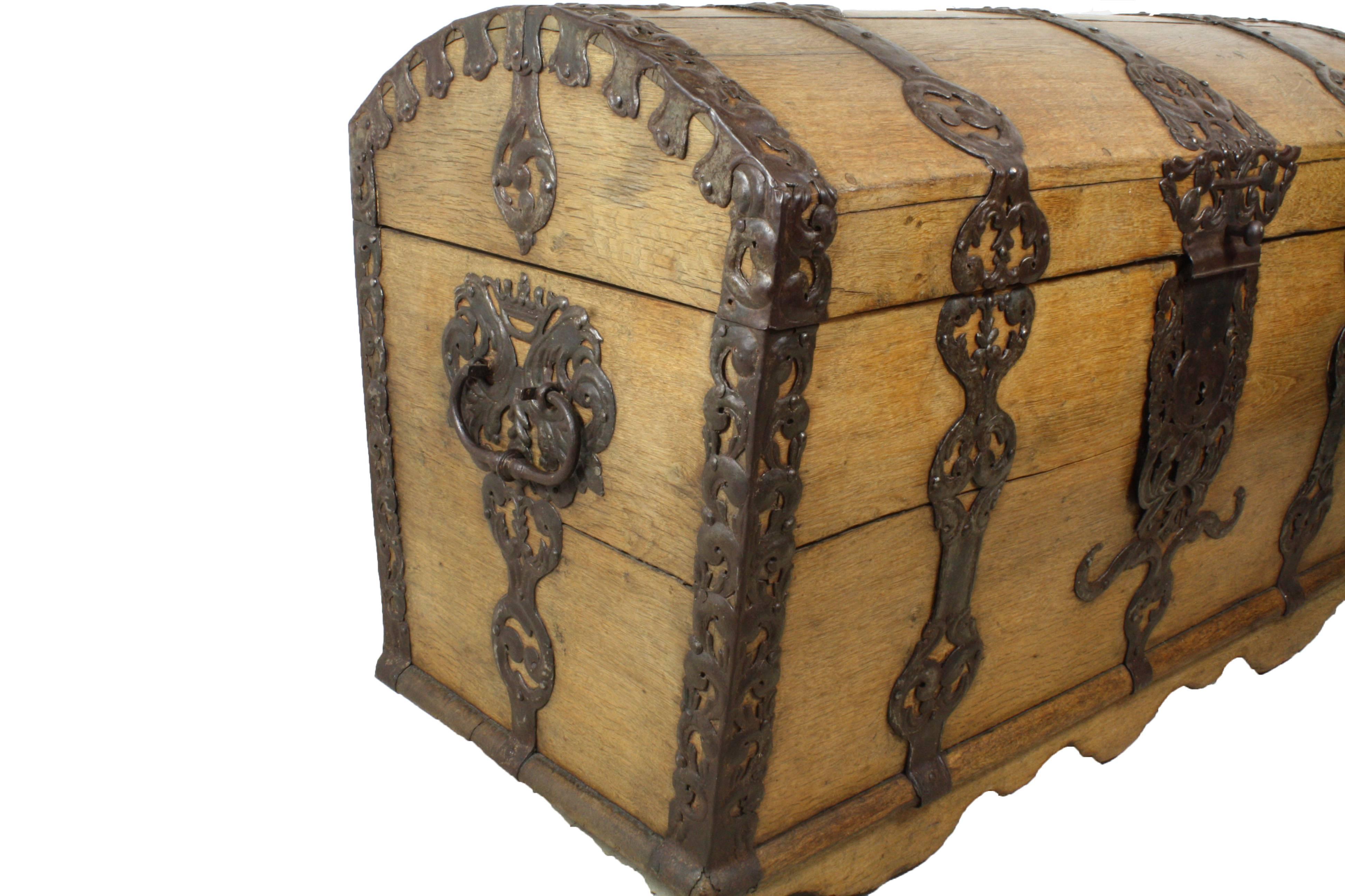 A substantial Dutch oak sea chest with beautifully detailed hand-forged and cut iron embellishments, from the Dutch golden ages. Full logs where drilled and used as rollers for transport and the lovely natural wax finish, which would protect the