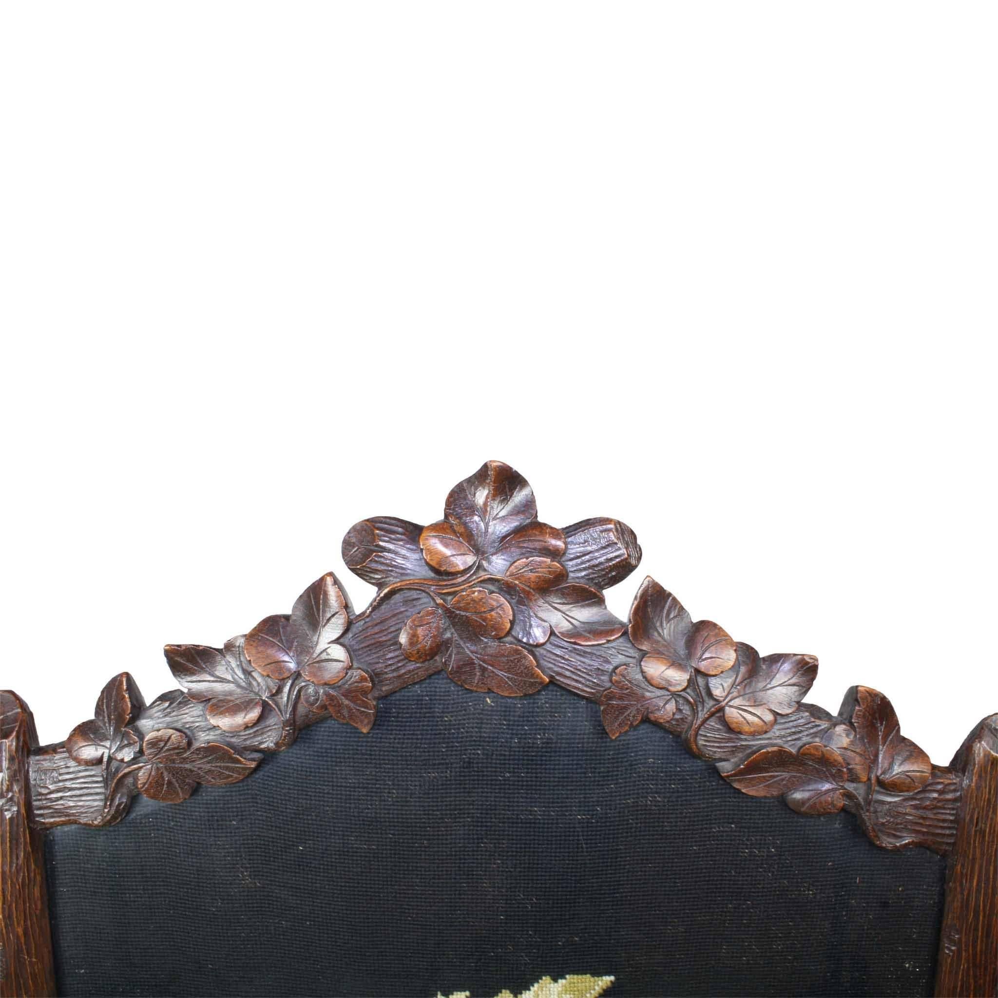 This floral needlepoint bouquet on a black background was added to this Swiss fireplace screen in the early 20th century. A handwritten note written in Dutch on the back of the screen reads May 15, 1936 by H. J. Boxman Muhl, most likely the person
