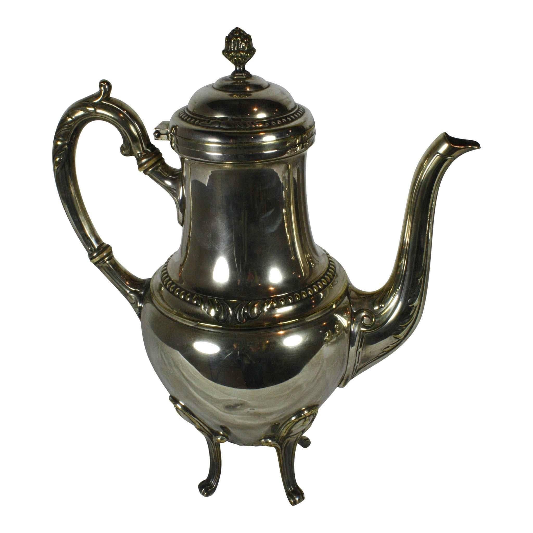 This complete five piece coffee and tea set is silver plated. Acanthus leaves are feature on all of the handles and the ceramic heat rings on are present and intact. All of the covers have matching decorative acorn finials. The coffee and tea pots