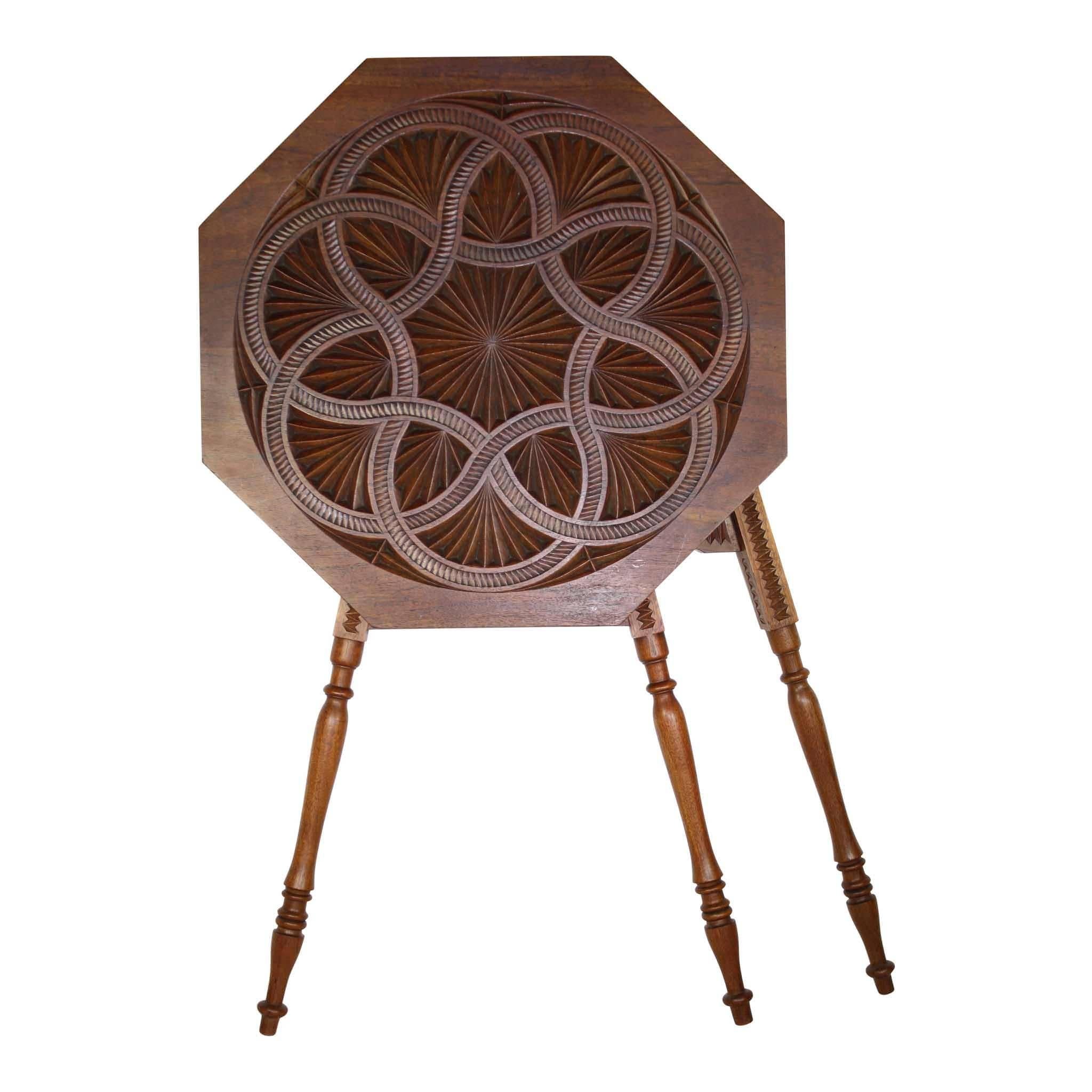 The beauty of this table is found in its symmetrical shape and carving. The octagon top bears a circle which is carved with a continuous rope design forming two heptagons. Precise carving between every section within the circle is extraordinary. The