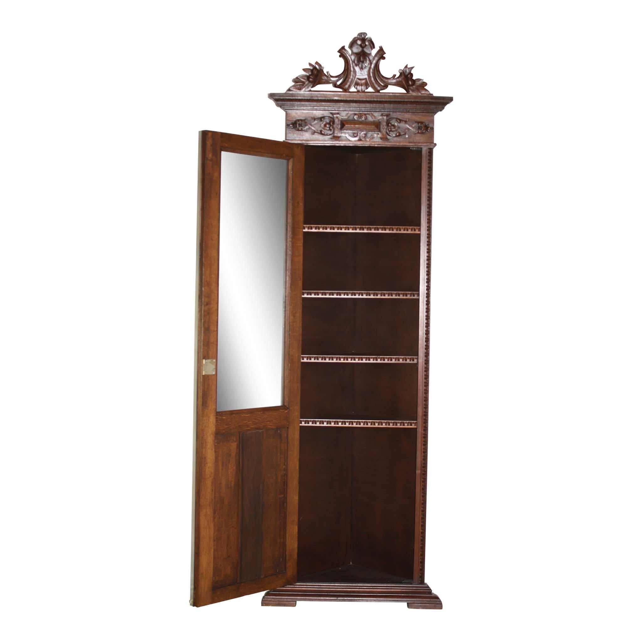 A distinct feature of this elegant corner cabinet is the grouse carved among grasses on the lower door. The crown of the cabinet displays ornate carvings with opposing lilies. The cabinet has matching trim on the sides and four shelves. Thin, yet