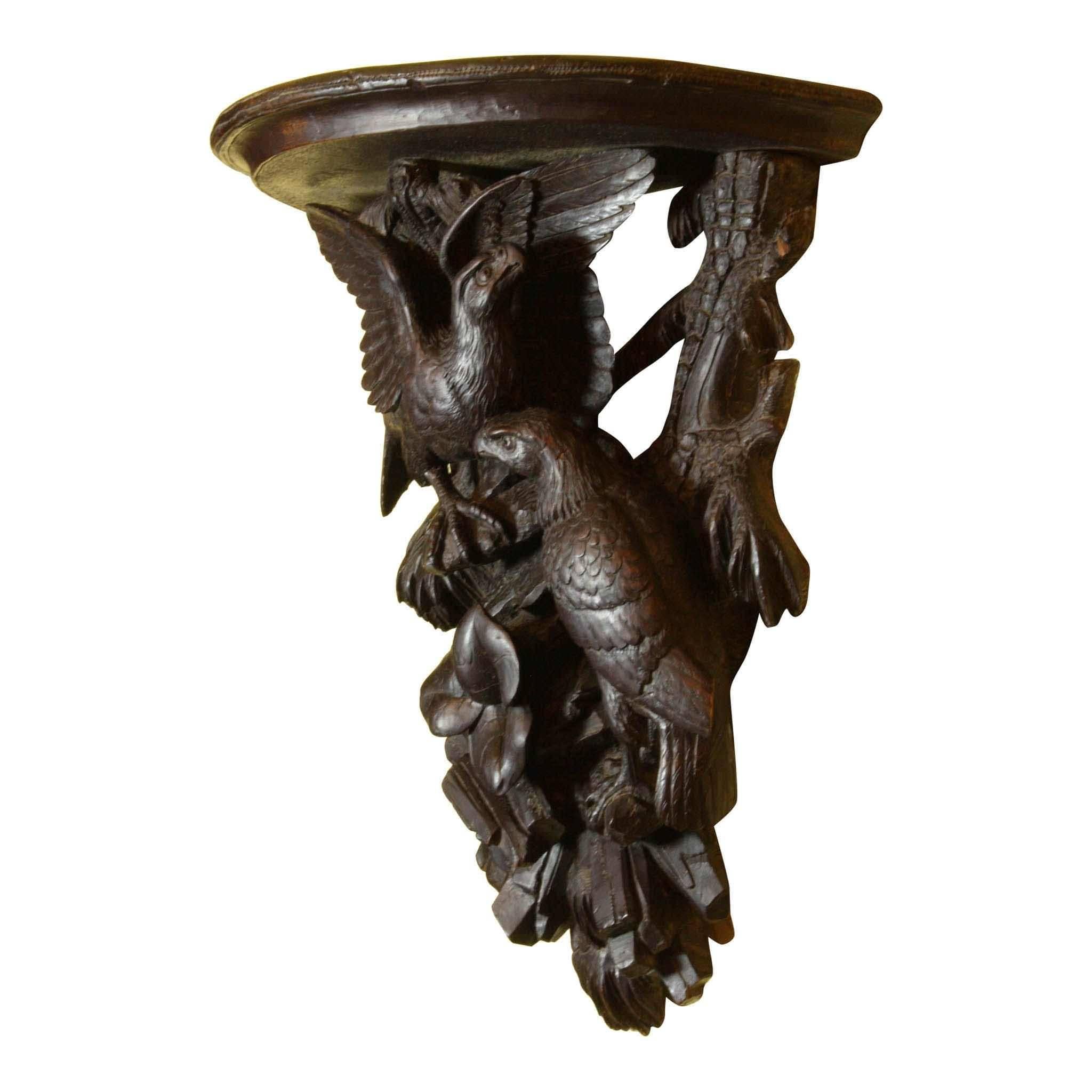 A nesting pair of Kestrels is perched on this carved Black Forest shelf. The quality of the piece is reflected in the detail. Notice the plumage and talons, the grooving on the branches, and the detail of the foliage. A lovely shelf.