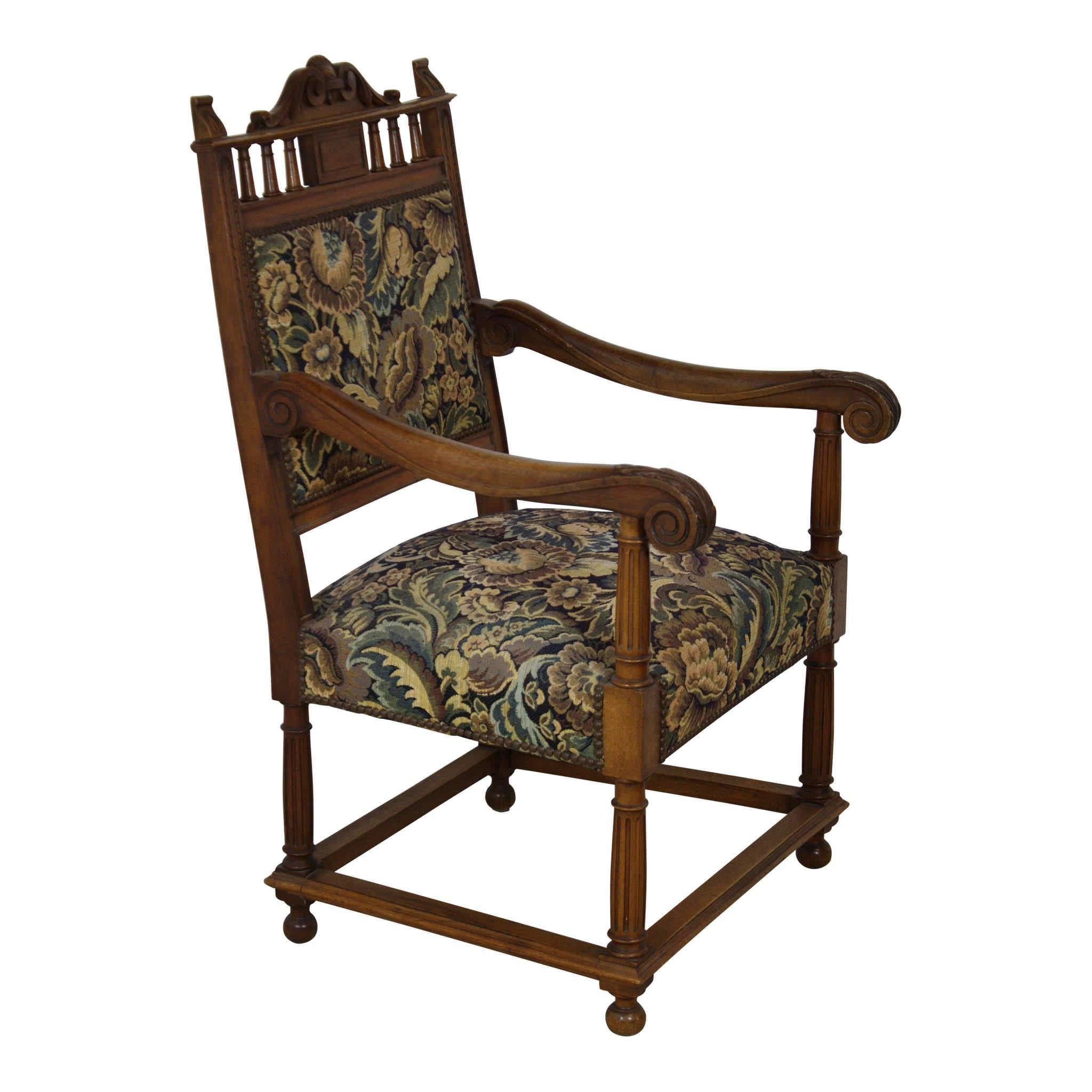 Solid and elegant, this set of walnut armchairs is well constructed with high backs, deep seats, and reinforced legs. The chair backs are crowned with a carved shell above small spindles. Acanthus leaves adorn the front of the scrolled arms. The