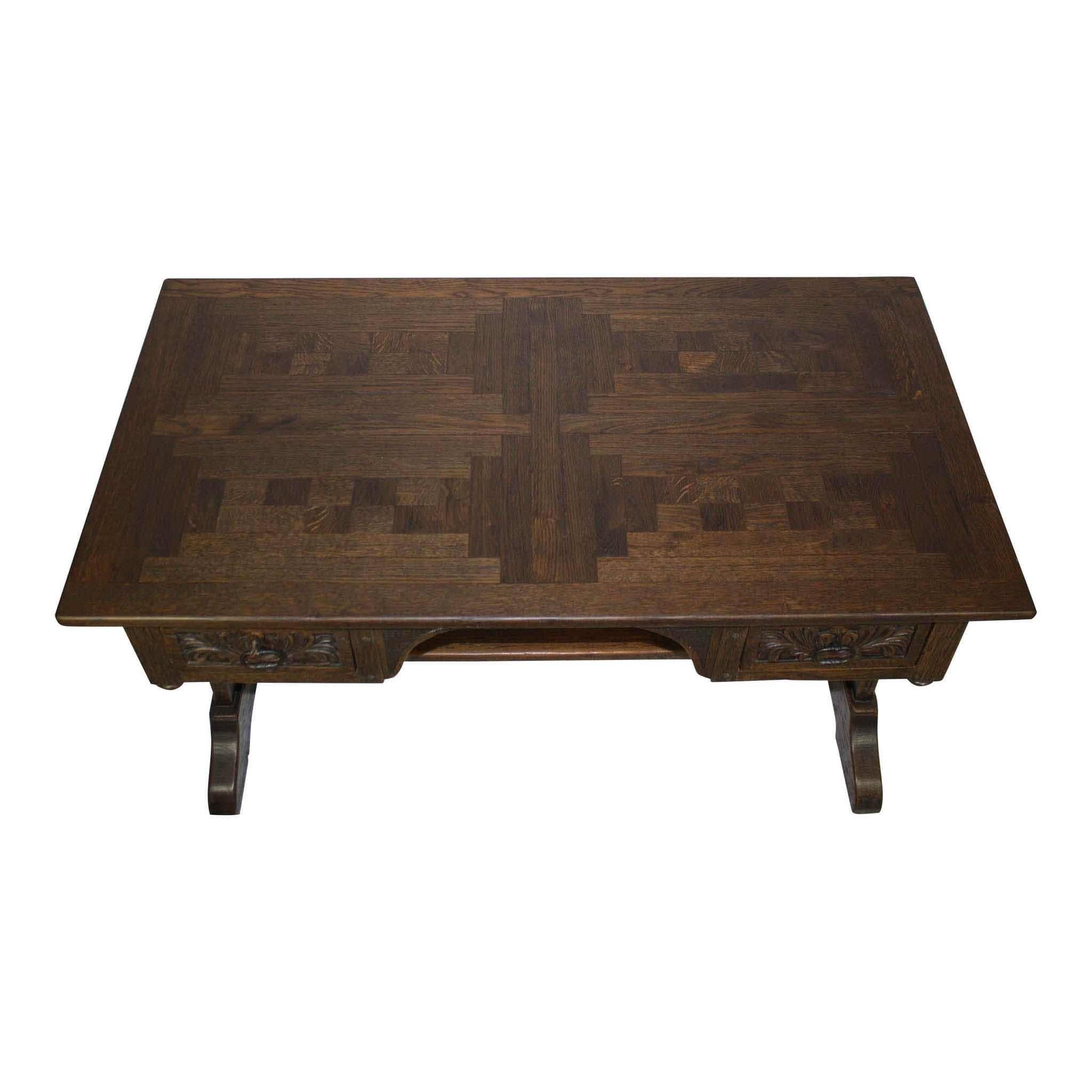 The cutouts on each side of this desk allow for two people to sit on either side. The desktop is beautifully veneered with a woven or braided pattern. A carved apron with decorative finials completes the piece.