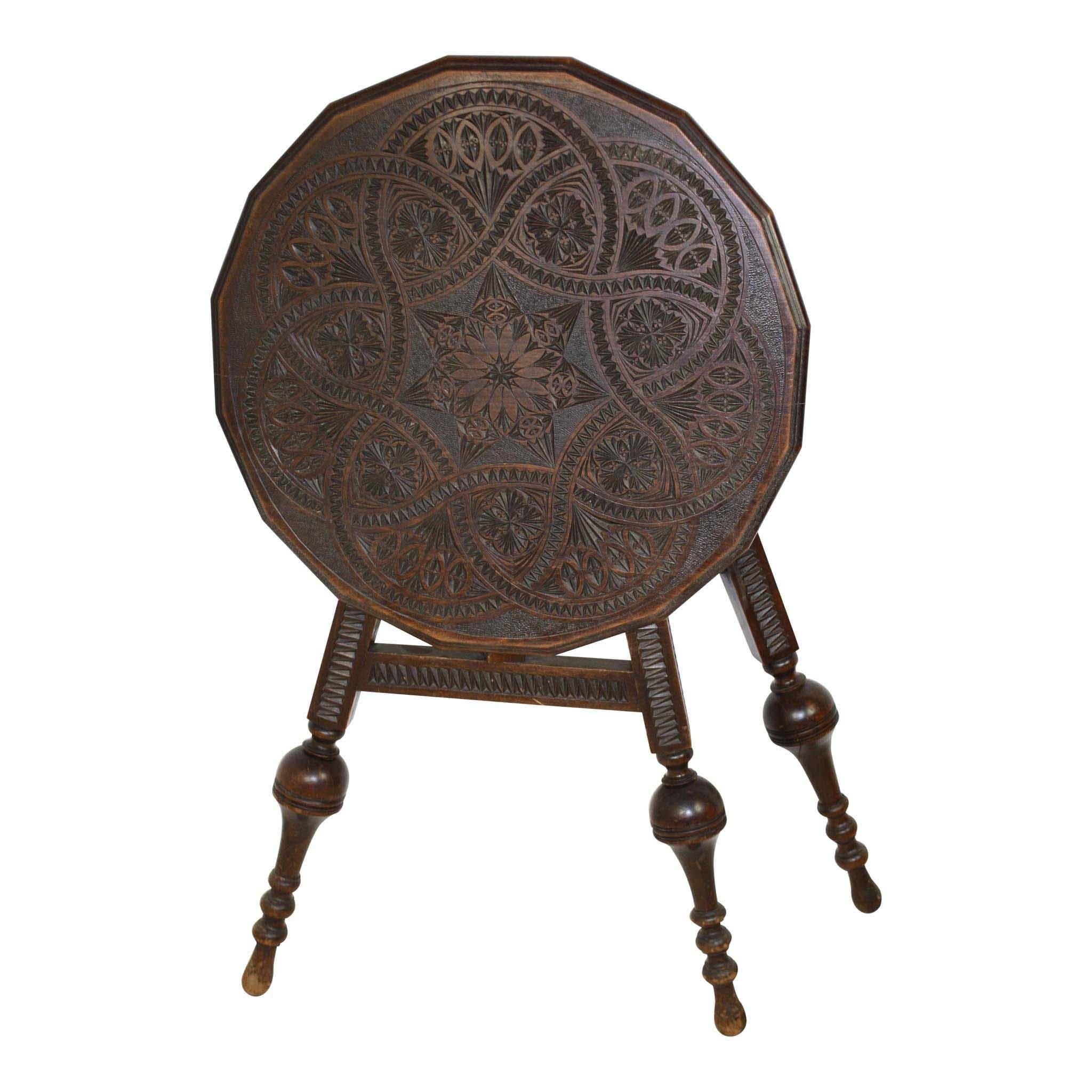The beauty of this table is found in its symmetrical shape and carving. The top bears a circle which is carved with a continuous rope design forming two heptagons. Precise carving between every section within the circle is extraordinary. The legs