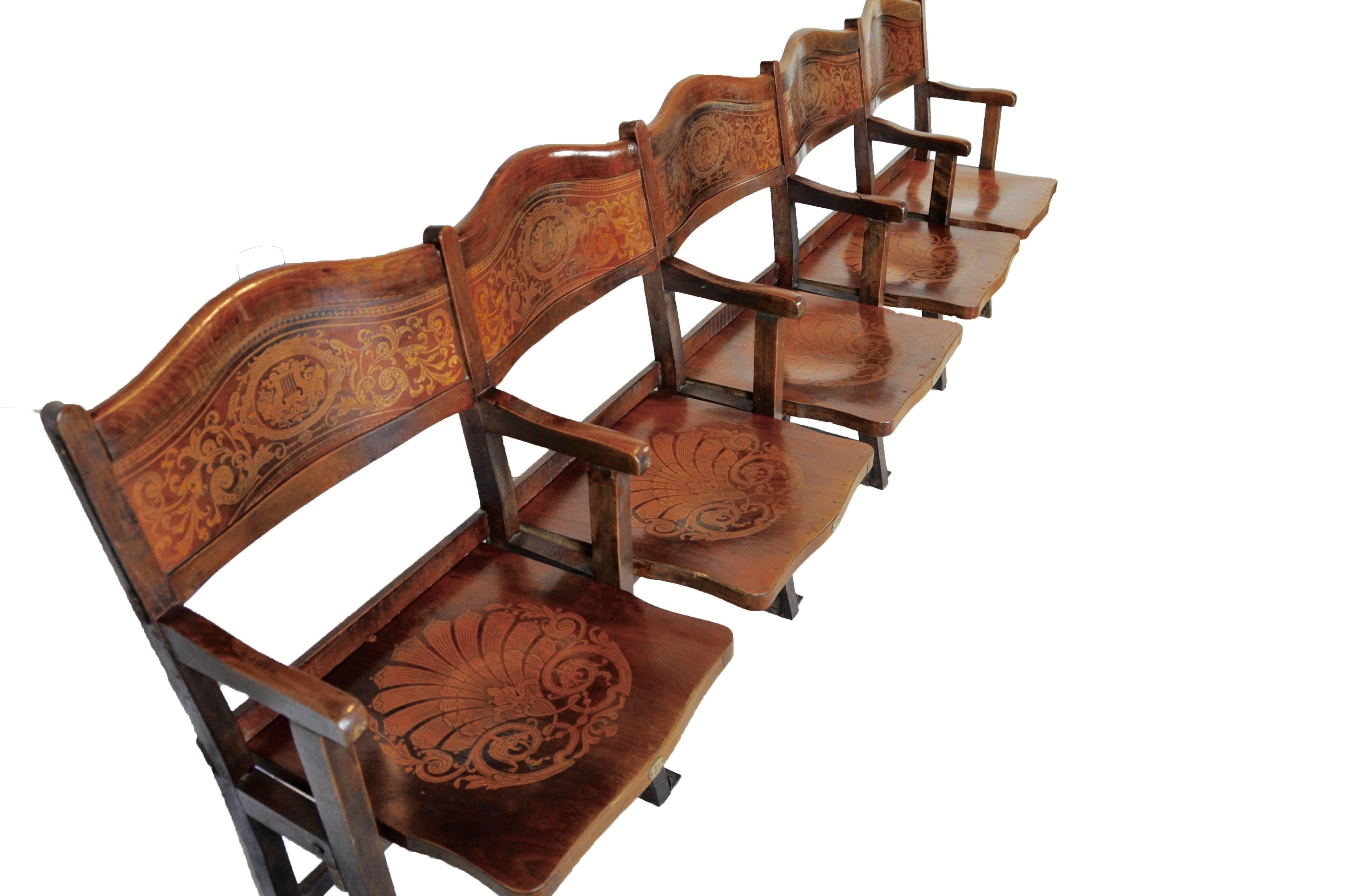 The rosewood and maple marquetry in the back rests and seats of this row of theatre seats from Belgium is exquisite. All five flip down seats are back waited, which brings the seats to their upright position. We have seen many wood theatre seats in