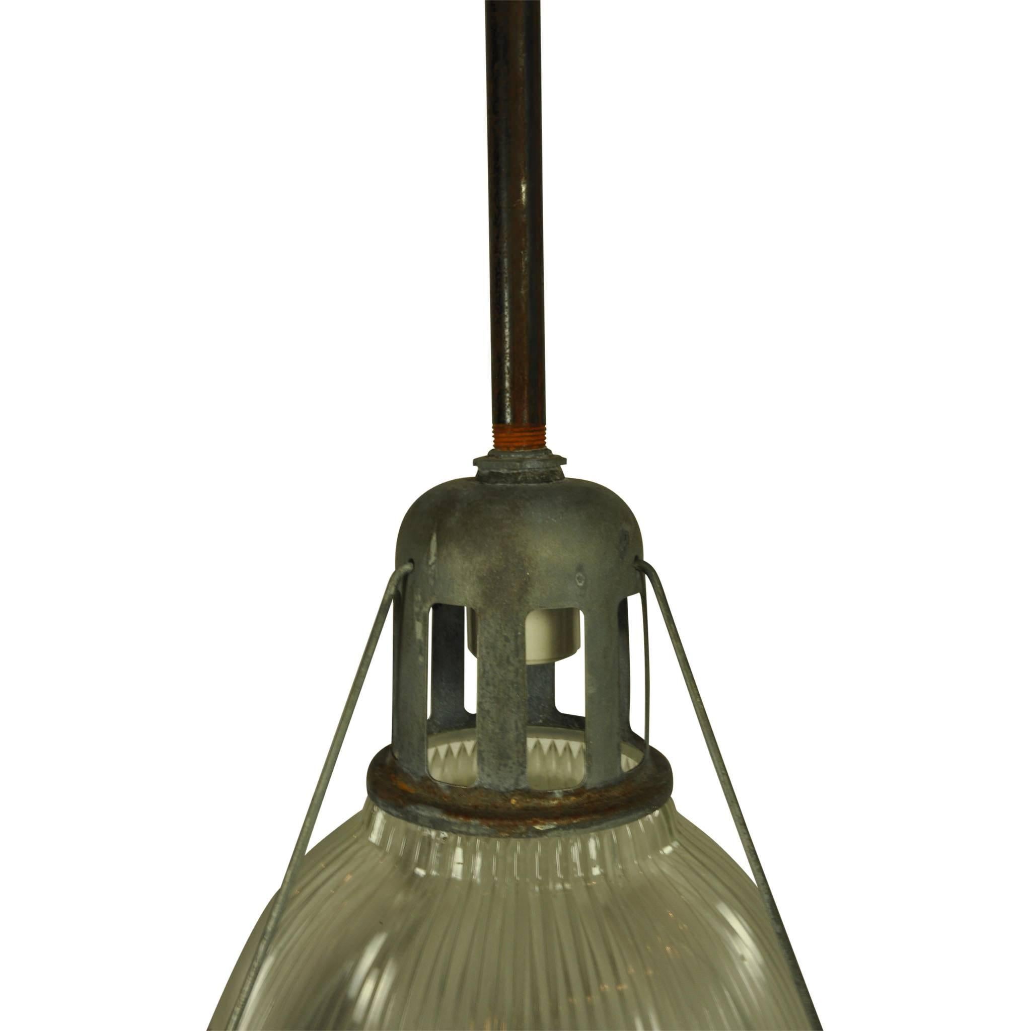 These industrial holophane fixtures once served in a turn of the century New England factory. The prismatic, domed glass has a lower metal ring. The brackets, stem, canopy, and crown are original.  The lights have been rewired. 