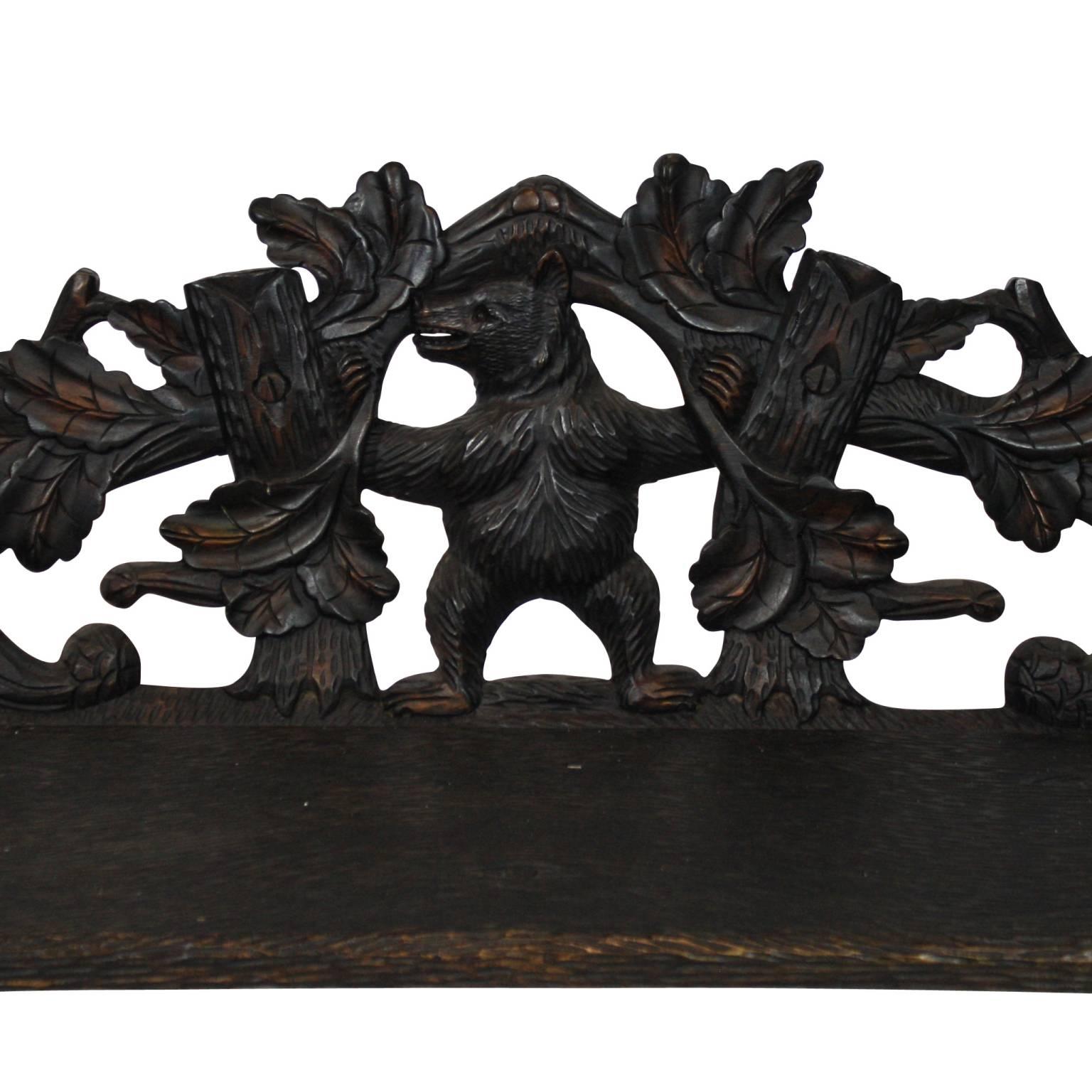 Swiss Black Forest bench, featuring two carved bears holding up a carved seat and back.