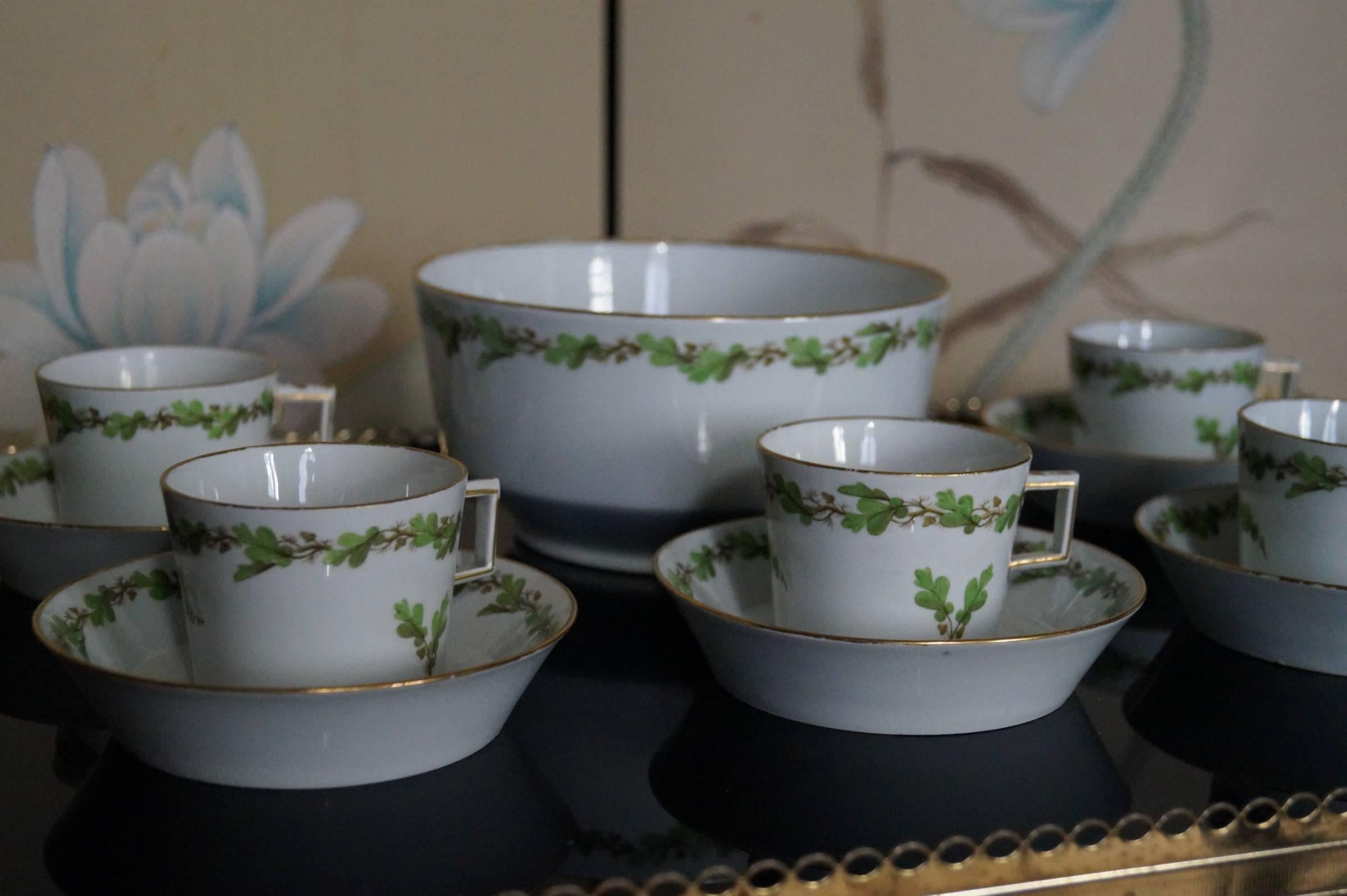 Antique Furstenberg porcelain demitasse cup and saucers and a bowl from the late 18th century.

All pieces are hand-painted in green with a Guirlande of oak leaves. All pieces have a nice gold rim. The square handles are typical for the classicism