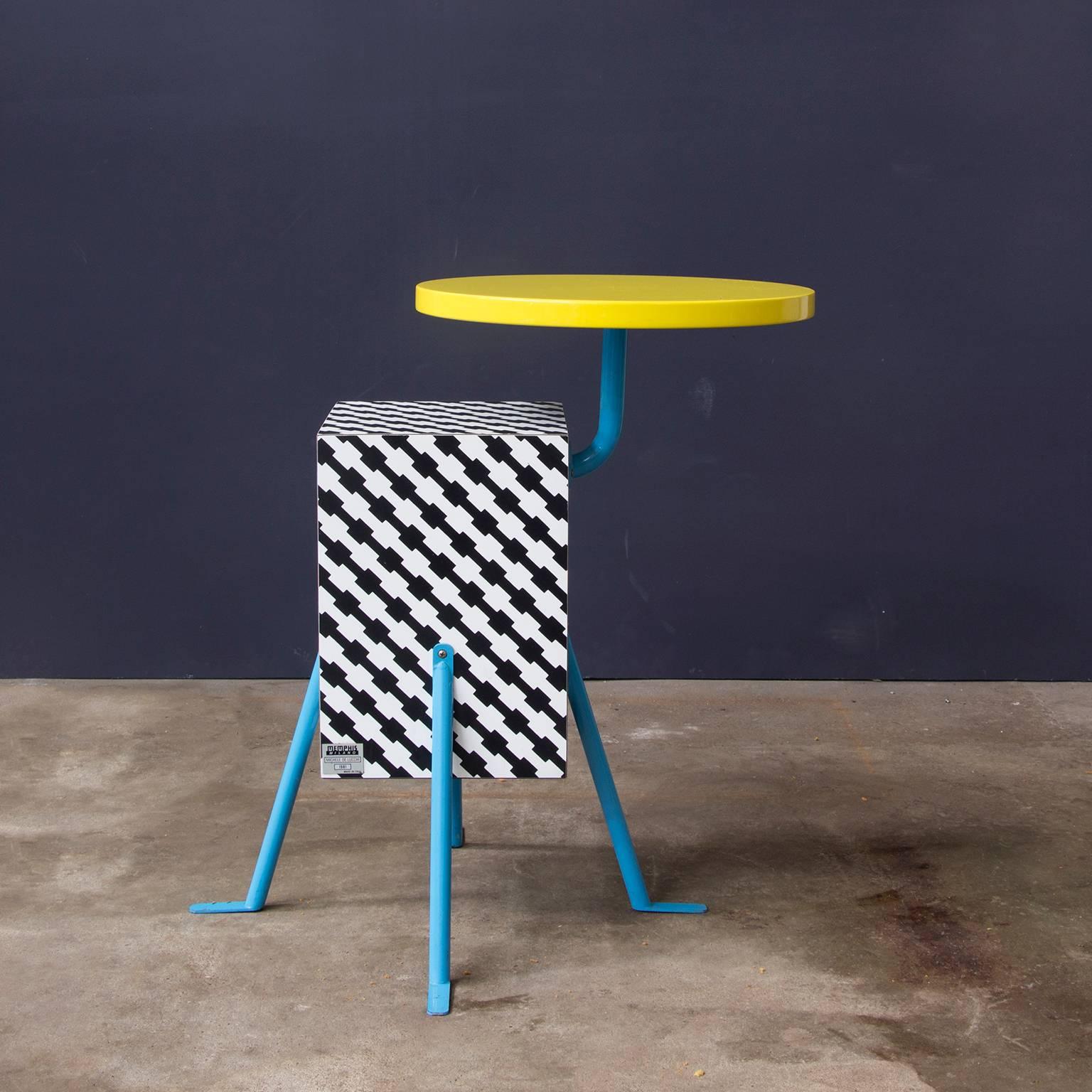 From the inaugural 1981 Memphis collection, this very popular design by Michele de Lucchi (one of the founding members of the design collective) implements a de Lucchi laminate design named "Terrific".
Beneath its bright yellow lacquered