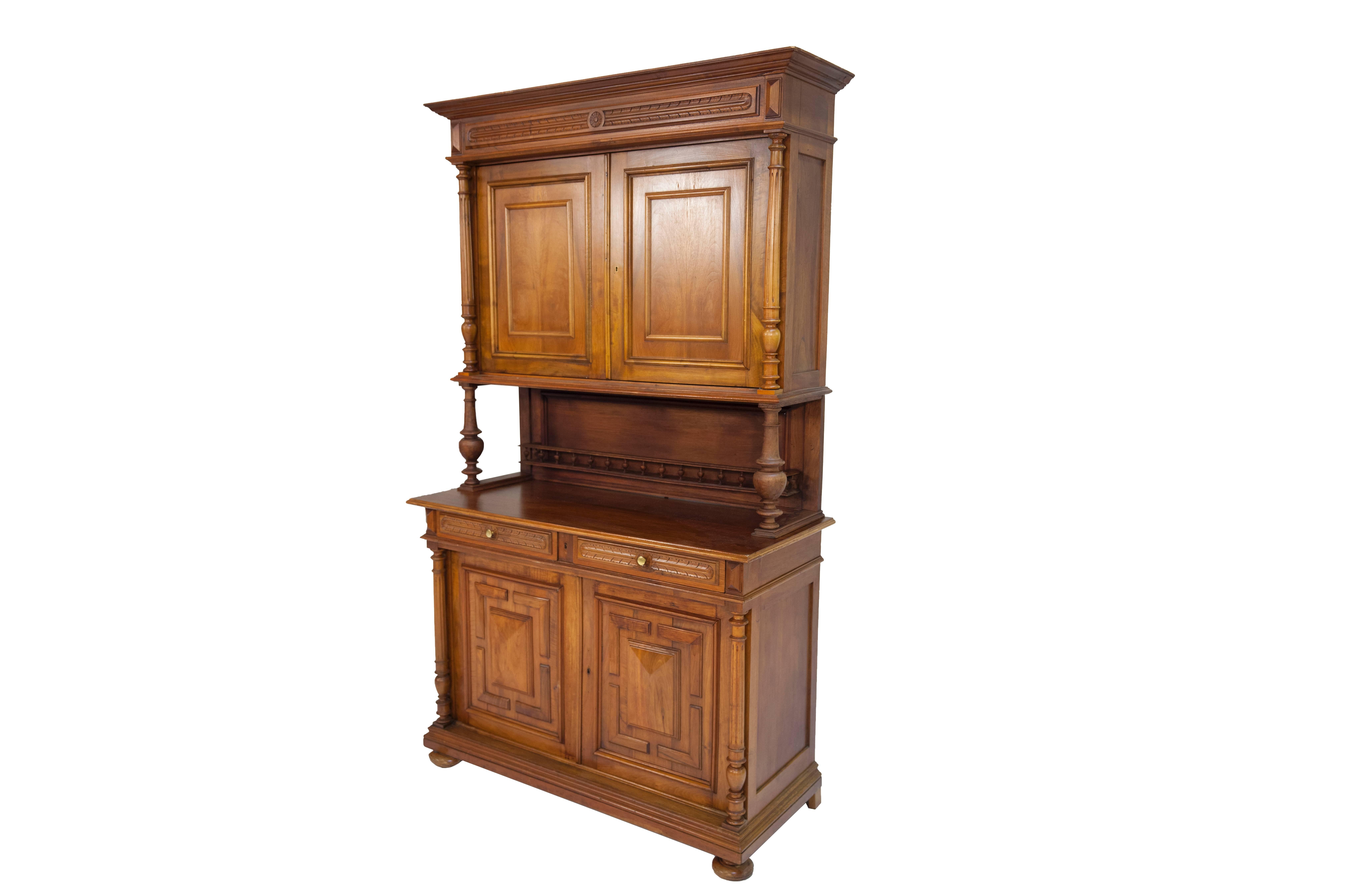 In very good condition. The credenza has two doors in its lower part with two drawers above; the panels set into the cut-outs of the doors in the lower part are double-coated with walnut and root wood and framed by profiled trims. Baluster columns