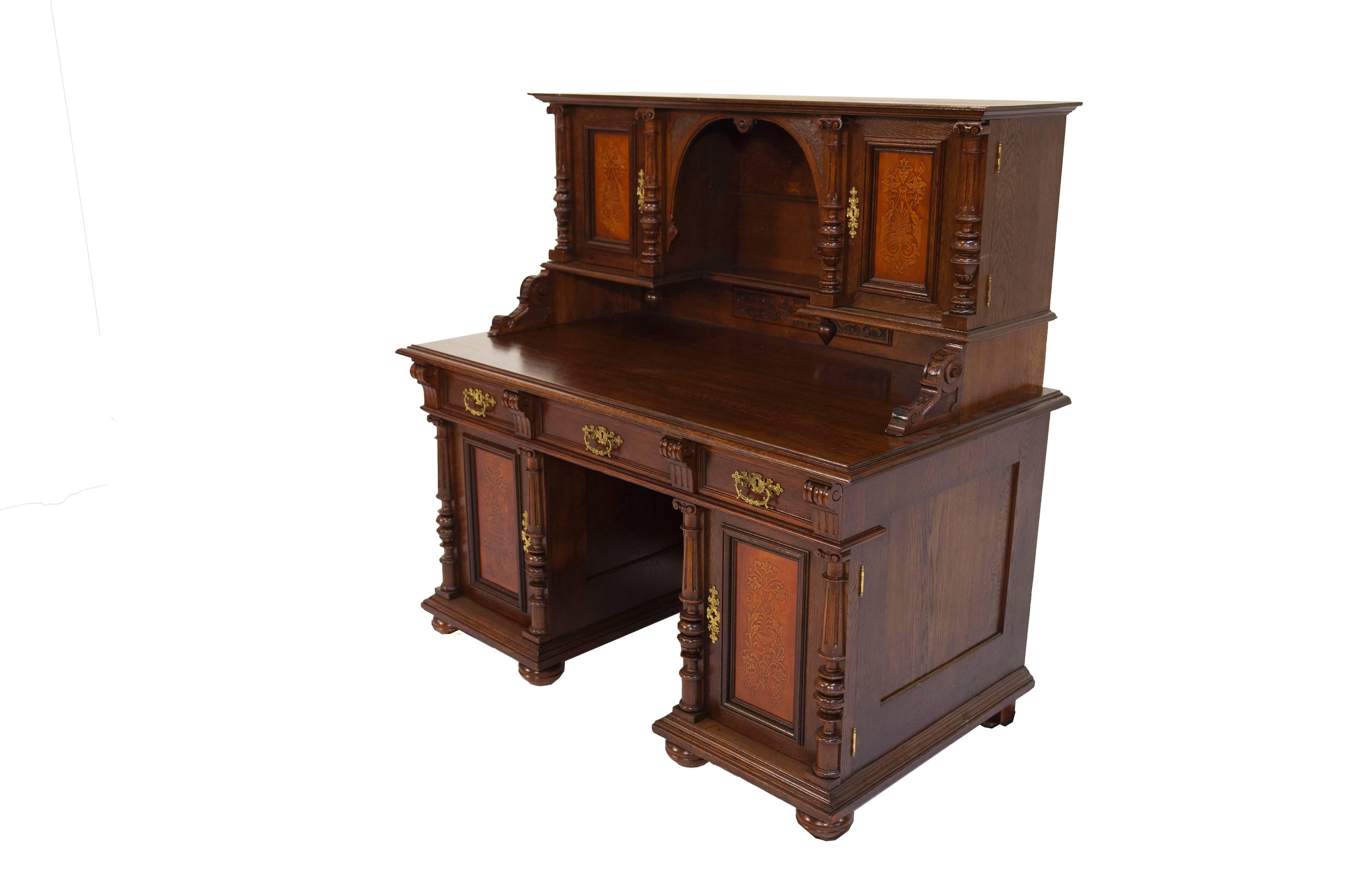 Below its writing surface, the writing desk has three drawers that can be locked. The writing surface rests on two blocks of drawers, and these are closed by doors. The cut-outs of the door are coffered and inlaid with ornamented panels. Behind the