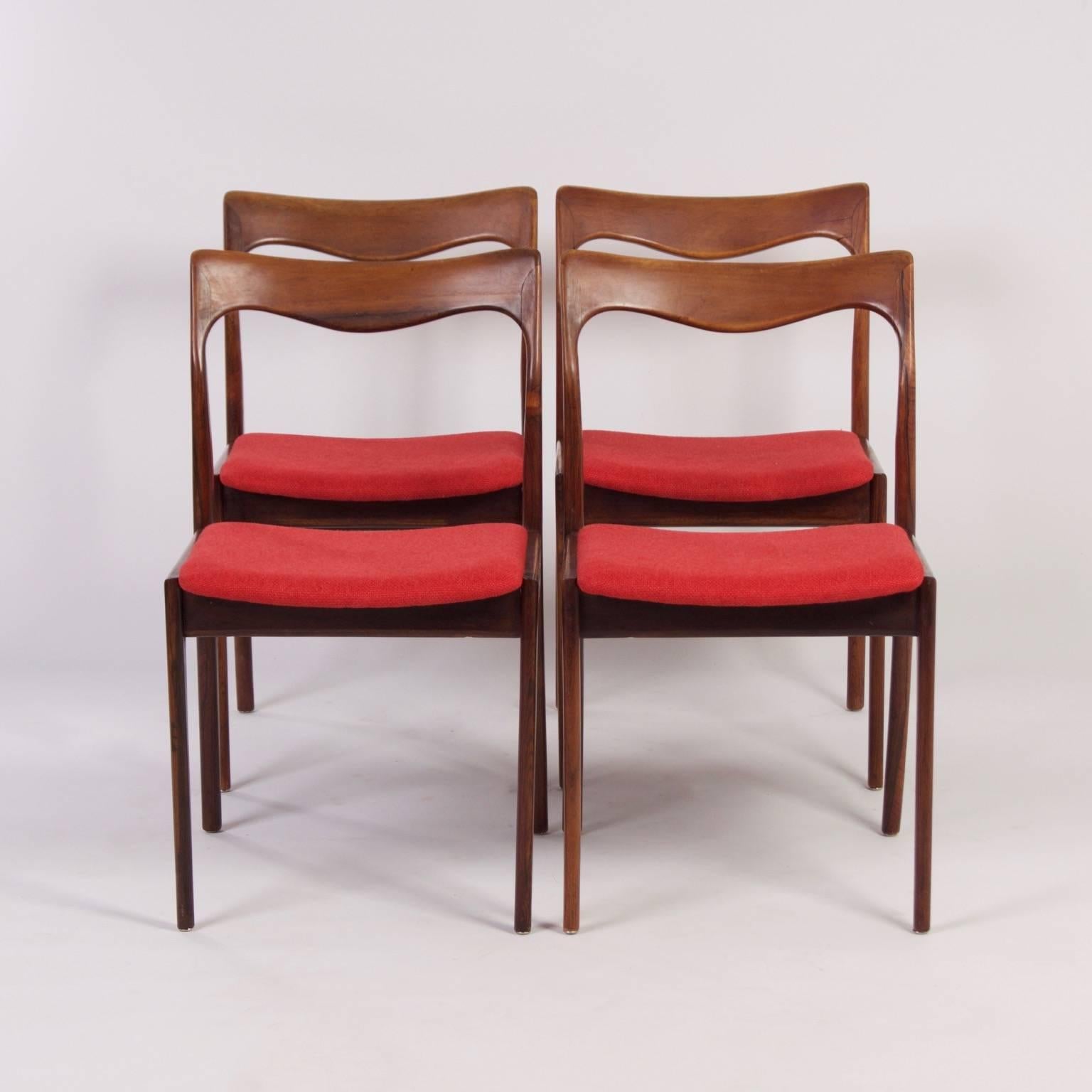 Red rosewood dining chairs designed by the Dutch furniture factory AWA, circa 1960. The rosewood frames have a very nice wood grain. Considering its age these chairs are still in very good condition. The chairs have been re-upholstered with red