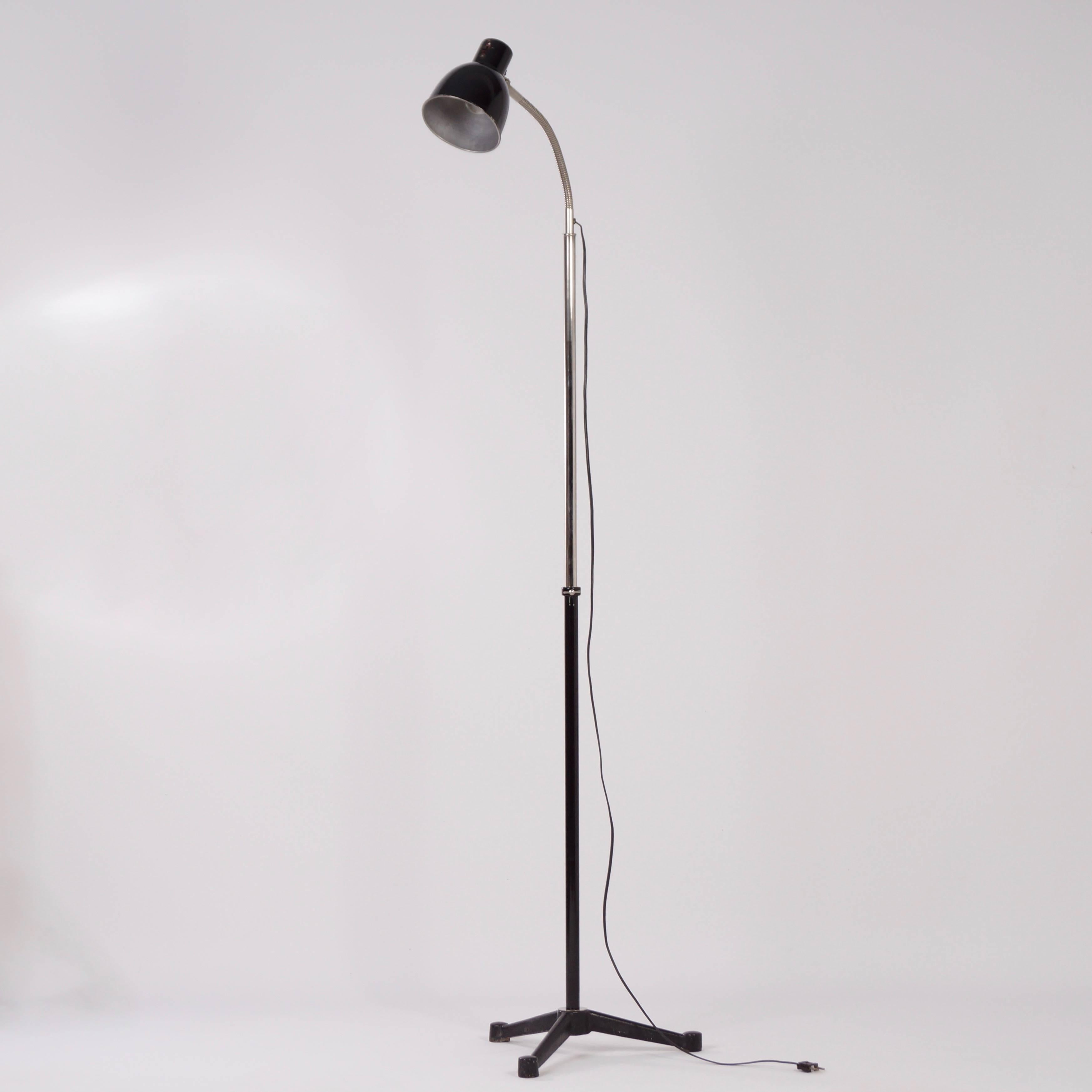 Industrial hala floor lamp designed by H. Busquet in the 1950s. This vintage Hala floor lamp has a nice tripod base that is adjustable in height of 123–184 cm. The shade is adjustable by the flexible arm. The lamp can be switched by a switch on the