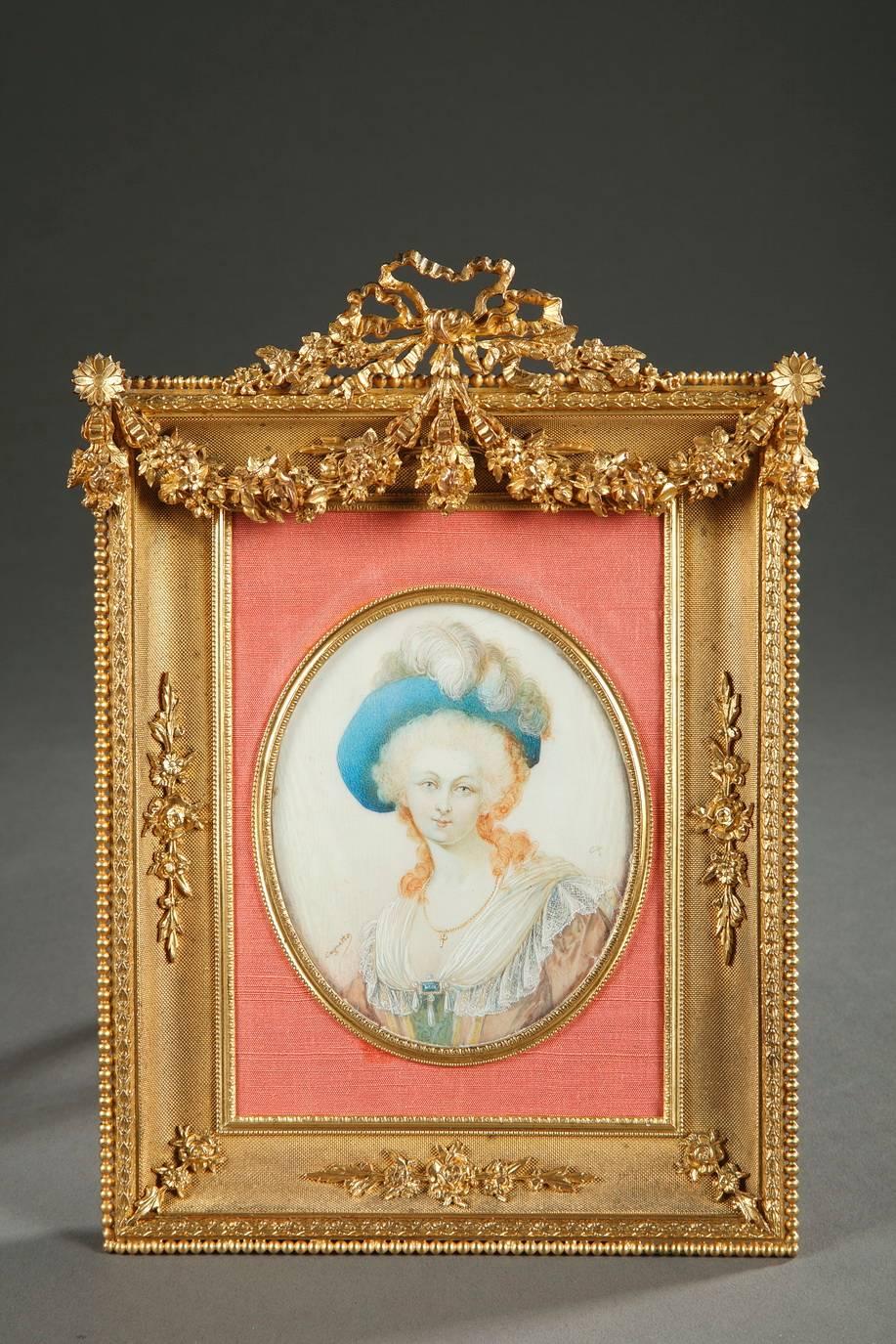 Exquisite 19th century gilt bronze frame for a miniature, hemmed with a frieze of beads and crowned with a ribbon. Two small flowers support a rich, double, flowering garland. The three other curved sides of the frame are intricately engraved with