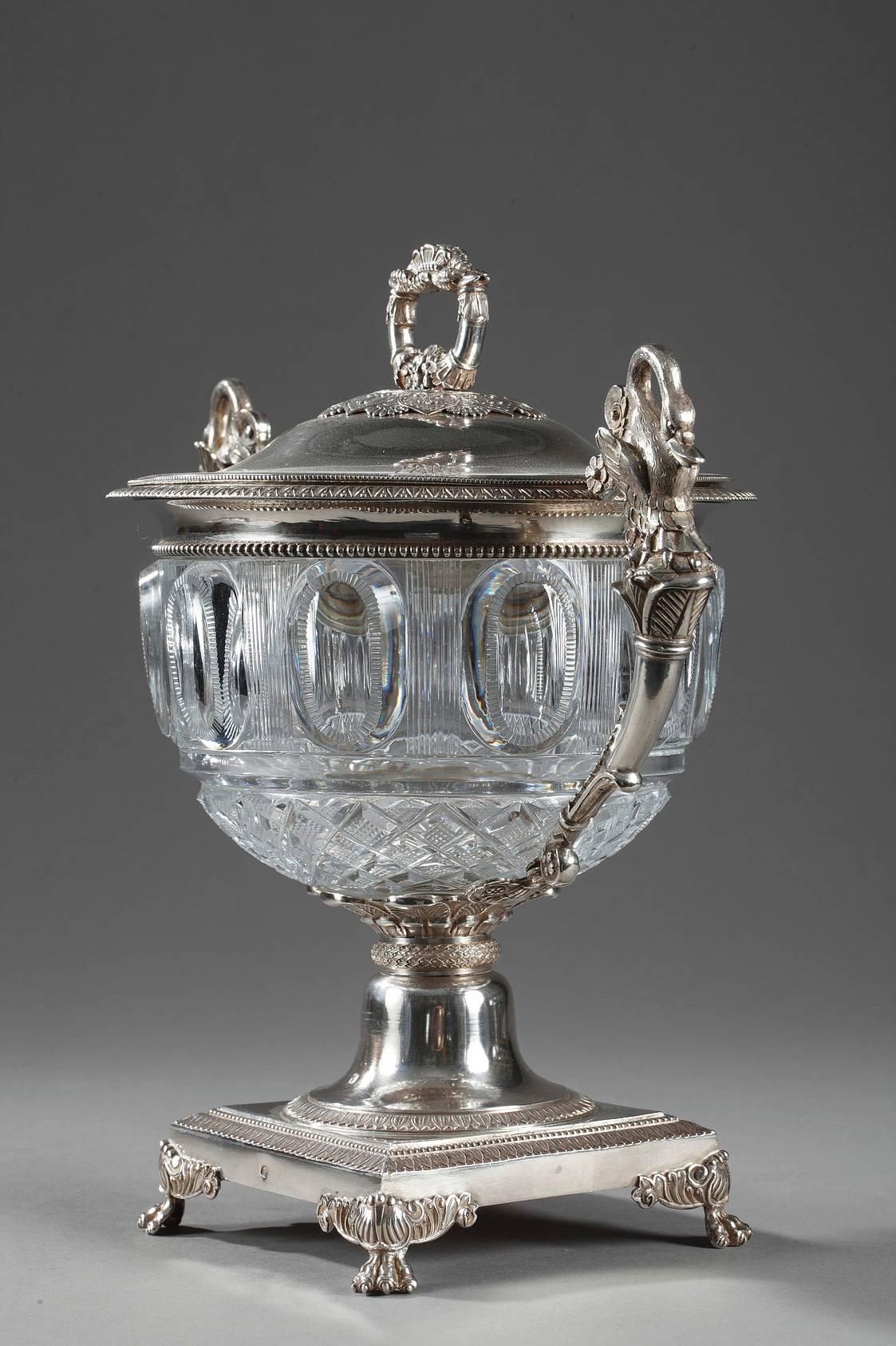 Sizable candy dish in silver and cut crystal from the Restauration period. The body is decorated with diamond cuts and ovals in relief. The handles that extend to the base are sculpted with swans, small flowers, and foliage. The monogrammed lid is