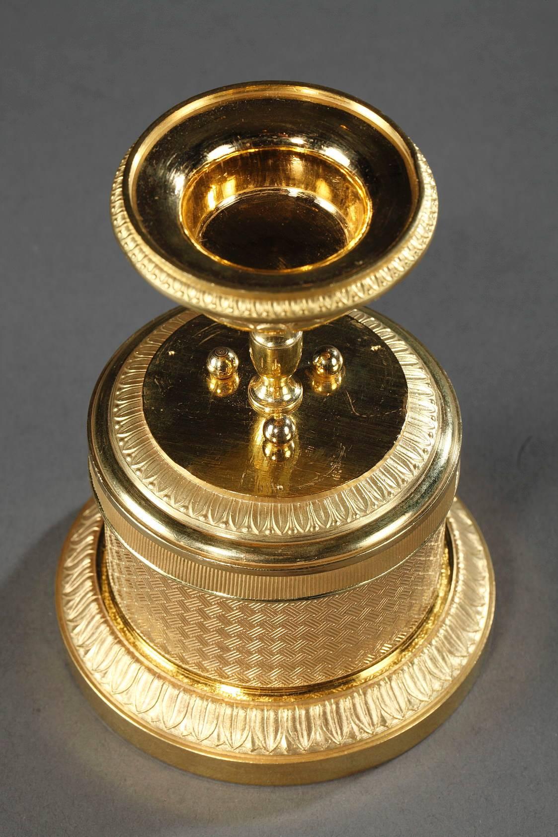 Combination trinket bowl and inkwell in gilt bronze. The lower portion features two ink pots, a pounce pot, and three pen holes. The exterior is expertly sculpted with latticework and water-leaf. The ribbed lid is topped with a cup that serves as a