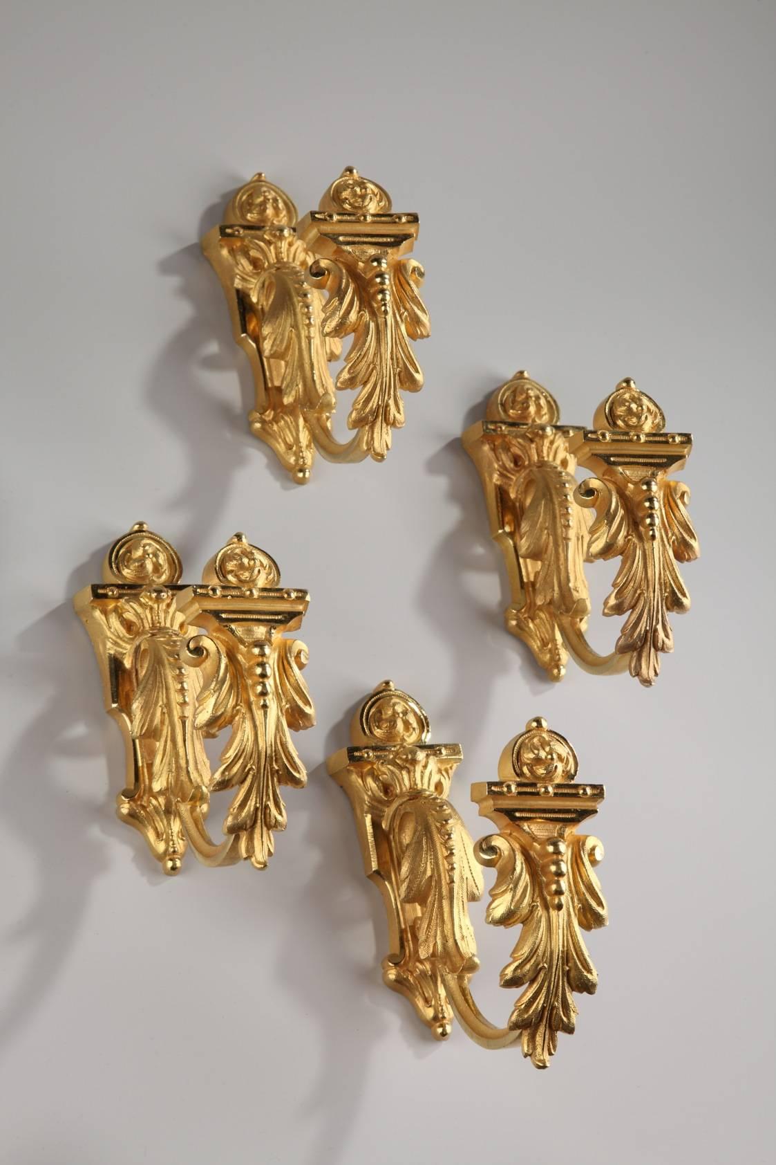Napoleon III set of four tie-backs in gilt and sculpted bronze decorated with capitals elaborated with acanthus leaves and topped by small flowers. All four are marked: 