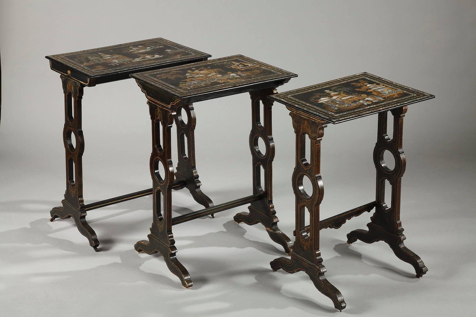 Napoleon III tables in blackwood accented with gold and mother-of-pearl. The tops of the tables are adorned with exotic landscapes inspired by the Far East featuring luxurious vegetation, pagodas, and characters discussing or walking. Each table