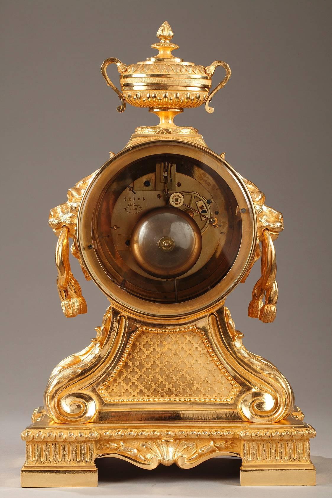 Napoleon III gilt bronze mantel clock in Louis XVI style. The clock is topped with a vase and supported by four scrolling consoles that are sculpted with laurel garlands. The enamel dial marks the hours with Roman numerals and the minutes with