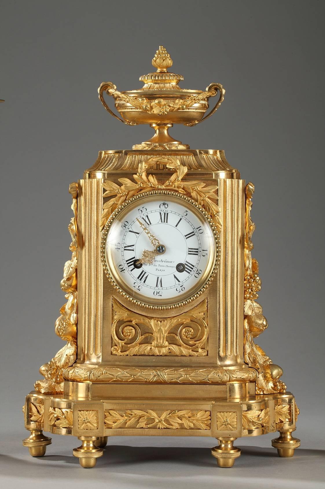 Late 19th century gilt and chiseled bronze set composed of a mantel clock and a pair of candelabras with five branches. The set is richly decorated with neoclassical garlands, arabesques, and flowers, and each piece rests on six toupie feet. The
