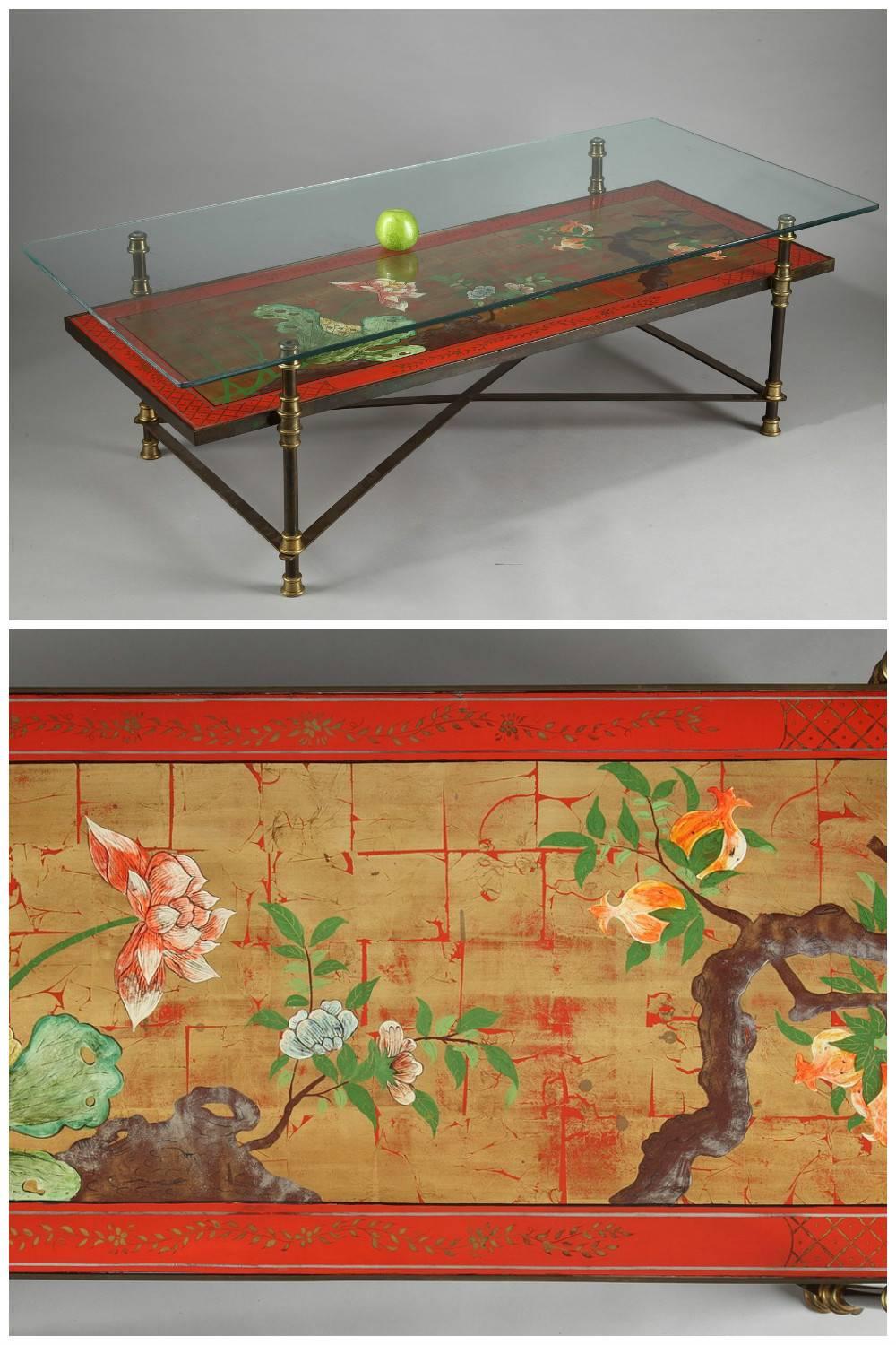 Large lacquered wood coffee table with Japanese polychromatic decoration featuring flowers and blossom tree on gilded background. It is resting on four brass and patinated bronze feet topped by a rectangular glass tray. Attributed to Maison Jansen