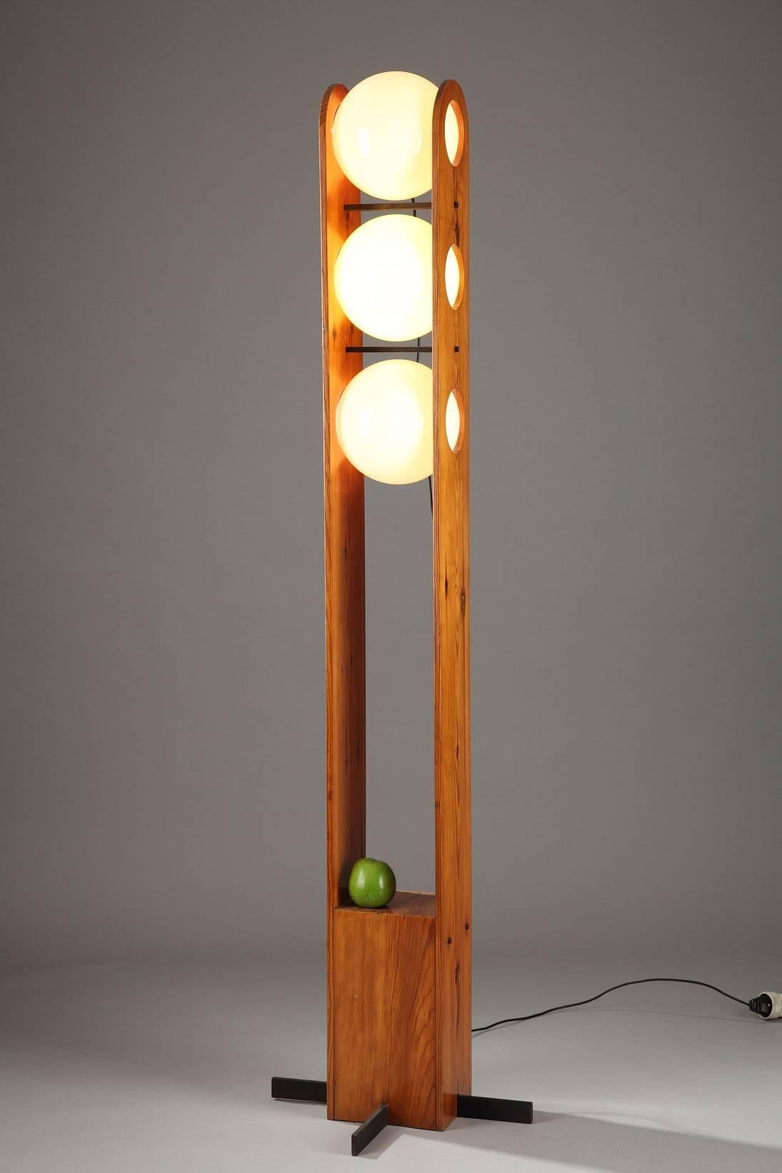 Chalet floor lamp, decorated with three balls in swivel white opaline, stuck between two larch amounts. Base ending with four black lacquered metal bars. In the taste of 