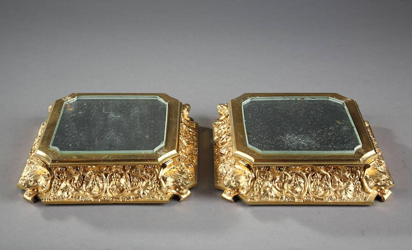 Pair of gilt bronze bases richly decorated with open-mouthed lion heads and vine leaves. Objects placed on these bases are consequently put in their best light,

circa 1825.
Dimensions: L 18cm, P 18cm, H 4cm.