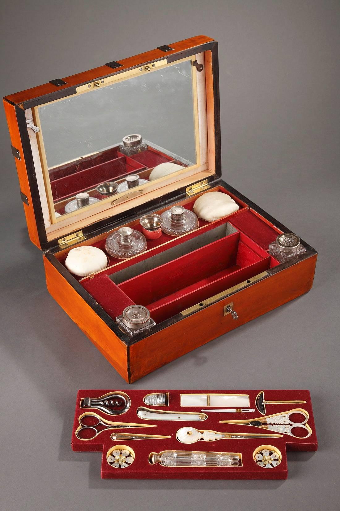 Varnished, wooden sewing box, decorated with hammered nails. The box contains a mirror and sewing utensils made of mother-of-pearl, crystal, and silver. The velvet tray of sewing tools can be removed to reveal the double bottom of the box,

circa