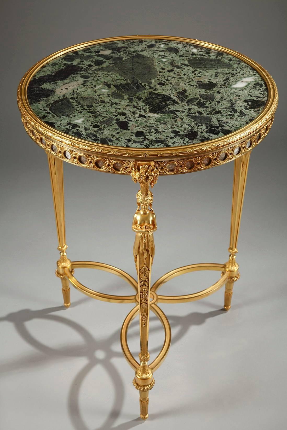 French 19th century gueridon in Adam Weisweiler taste, featuring a round, green, vert de mer marble tray and three graceful legs. The marble top is framed in gilt bronze, which is over a ring of gilt bronze openwork foliage over red marble. The tops